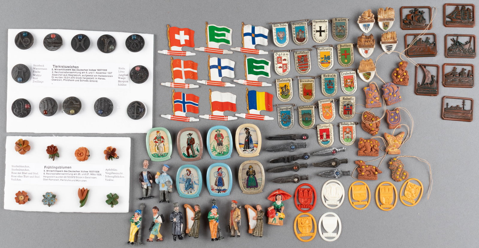 100 WHW WINTERHILFSWERK DONATION TOKENS: WHW Winterhilfswerk donation tokens, including sword tokens, country flags, porcelain figures, clay figures, astrology signs, and more. Some heads may be broken on figures.