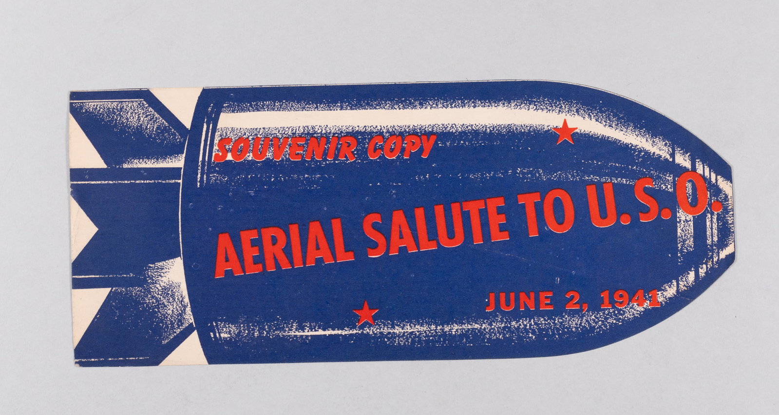 WWII HOMEFRONT PROPAGANDA LEAFLET AERIAL SALUTE TO U.S.O.: WWII American Homefront propaganda leaflet. In the shape of a bomb, one side reads 'Souvenir Copy / Aerial Salute to U.S.O. / June 2, 1941.' The reverse reads in part, 'No... This isn't a Bomb / It wa