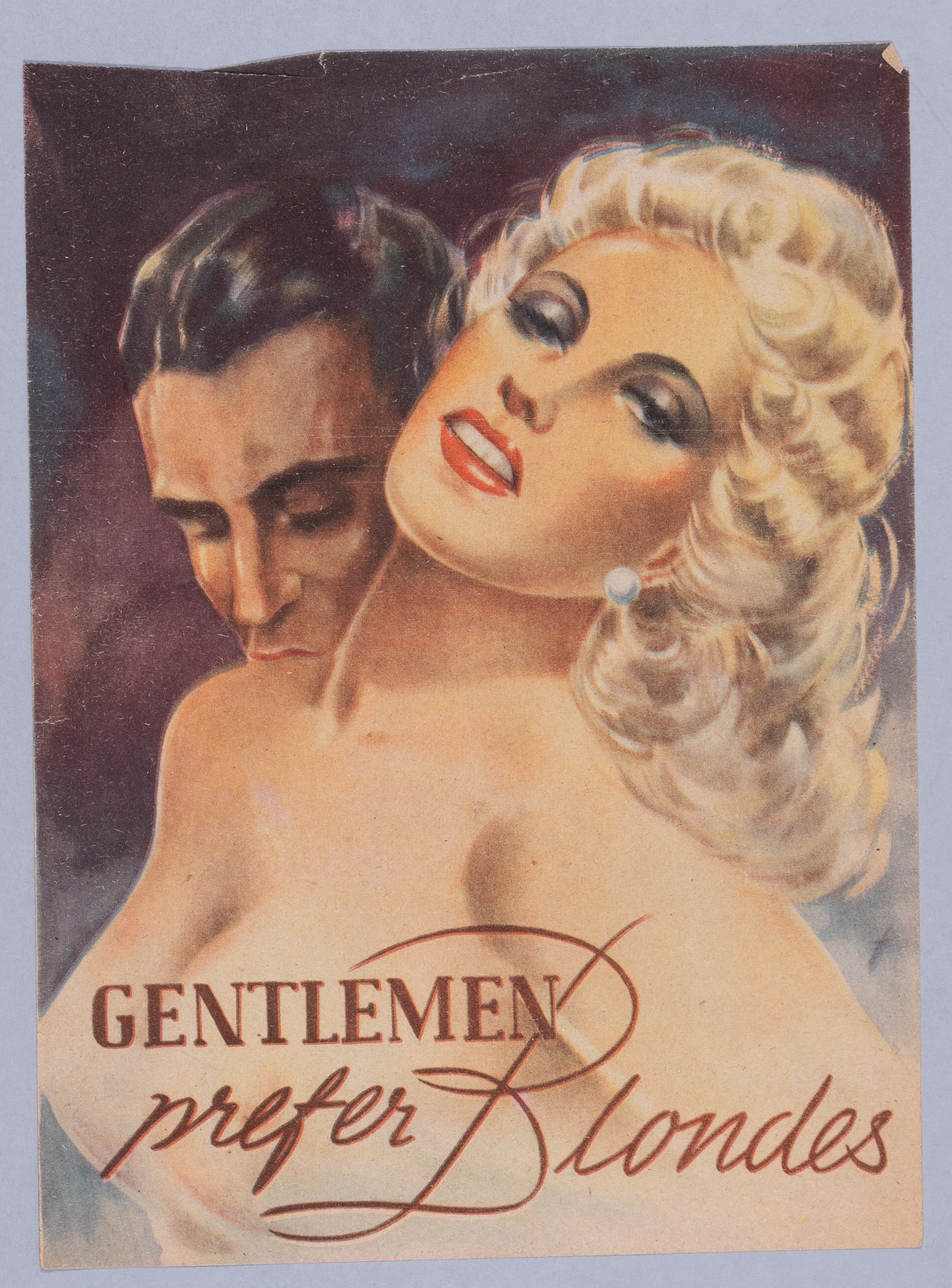 WWII GENTLEMAN PREFER BLONDES PROPAGANDA LEAFLET: WWII German anti-Allies propaganda leaflet, one side of a soldier embracing a blonde woman that reads 'Gentlemen prefer Blondes,' the reverse features a crippled soldier and reads 'but Blondes don't