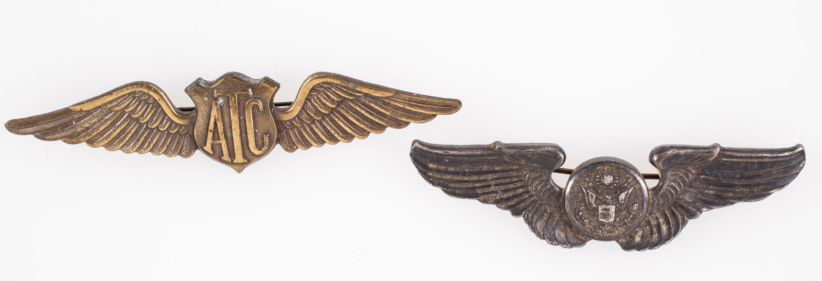 TWO WWII US ARMY AIR FORCE WINGS: WWII Air Transport Command pilot wings, horizontal straight pin, unmarked, 3.5 inches long.WWII Sterling Air Crew Wings, marked 'Sterling' on the reverse, horizontal straight pin, 3 inches long.