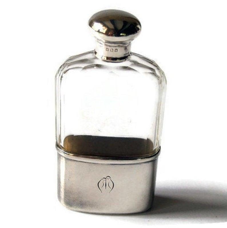 1918 ENGLISH SILVER AND CRYSTAL HIP FLASK: A crystal and solid silver flask. Fully hallmarked for sterling silver, London assay and the date letter for 1918. The maker's mark is illegible.Dimension:H 13 cm W 6.5 cm D 3 cmAll measurements are a