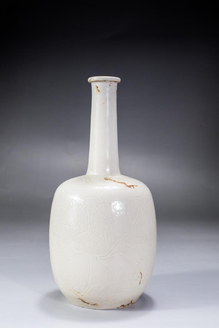 A SONG DING WARE WHITE GLAZED LONG NECK VASE: A song ding ware white glazed long neck vase, engraved with peony blossom. Song dynasty period, Ding Kiln.Dimension: H 25 cm, Diam 11.5 cm.All measurements are approximate. To view additional photos, 