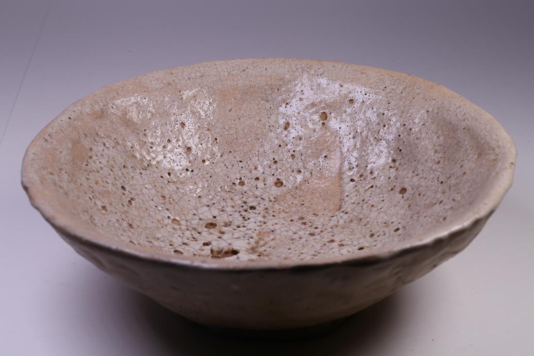 JAPANESE EDO PERIOD MATCHA TEA POTTERY BOWL: Japanese Edo period matcha tea pottery bowl. The simple shallow bowl shape, raised on narrow foot ring. The exterior is left un-glazed, carved with Japanese characters. Dimension: H 5 cm, W 16 cm. Wei