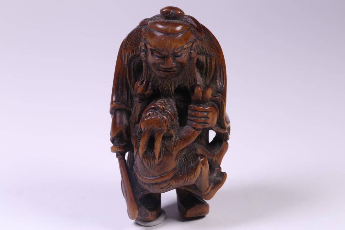 JAPANESE EDO PERIOD BOXWOOD CARVING FIGURE: Japanese Edo period boxwood carving figure of an old man carrying a kid in one hand while holding a sword in the other hand. Dimension: H 7 cm, W 3 cm. Weight: 27.5 g. All measurements are approximate