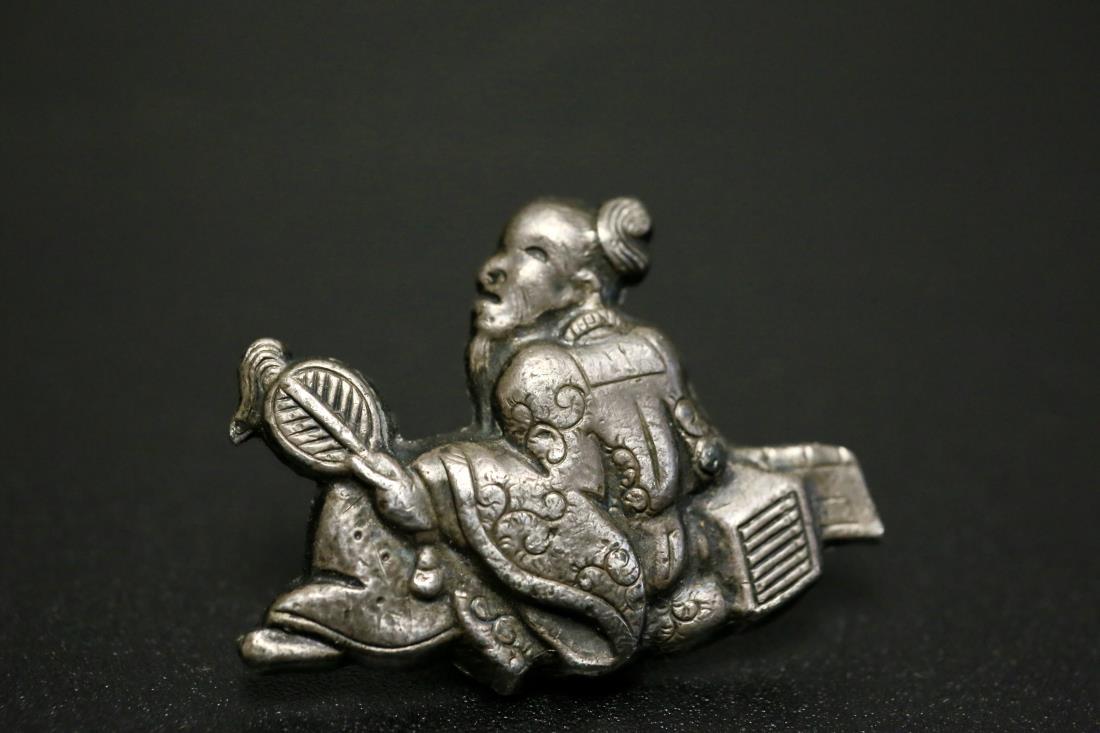 A TIN 'ZHUGE LIANG FIGURE' TOBACCO POUCH BUCKLE: A tin 'Zhuge Liang figure' tobacco pouch buckle, Japanese Meiji Era. Dimensions: H 3.5 cm. Weight: 6.72 g. All measurements are approximate. Provenance: property from a private collector in Pittsburgh