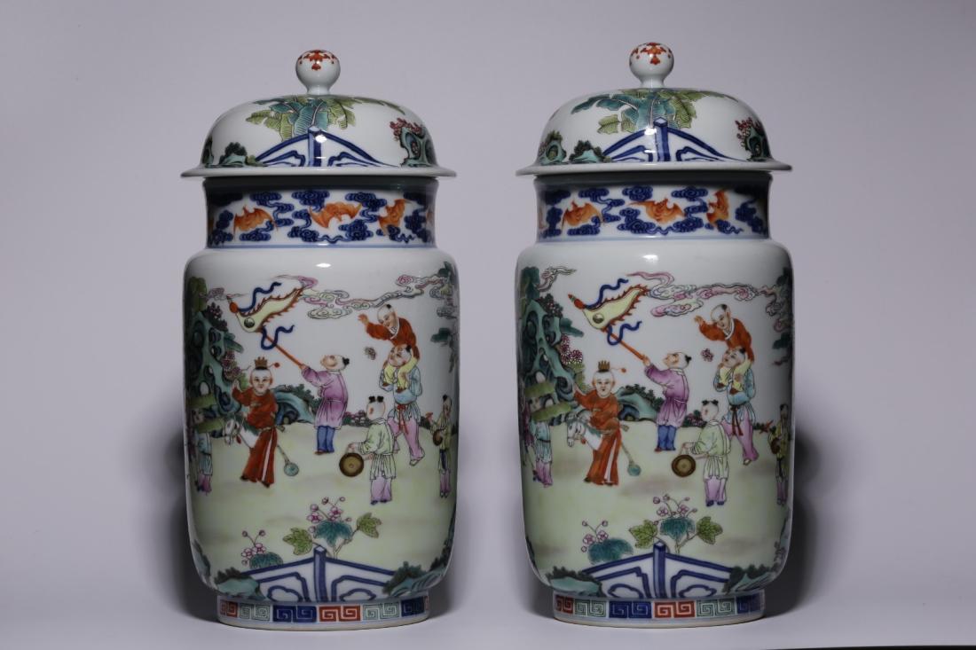 PAIR OF FAMILLE ROSE PORCELAIN JARS AND COVERS: Pair of famille rose porcelain jars and covers adorned with children playing in garden. There is a six-character mark "Da Qing Qian Long Nian Zhi" on the bottom. Dimensions: H 31 cm. All measurements