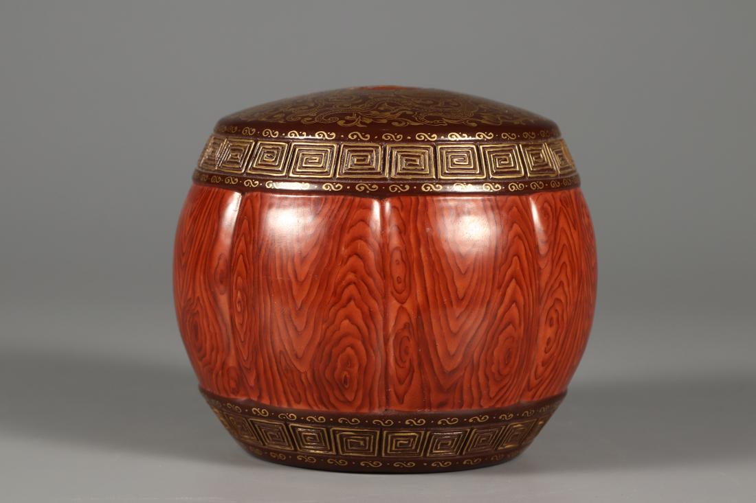 AN IMITATION WOOD-GRAIN GLAZED PORCELAIN STOOL: An imitation wood-grain glazed porcelain stool. There is a six-character "Da Qing Qian Long Nian Zhi" on the bottom. Dimensions: H 9 cm, Diam 11 cm. All measurements are approximate.