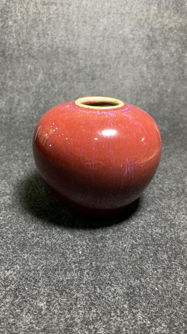 RED GROUND FAMBE GLAZED WATER POT: Red ground fambe glazed water pot. Dimensions: Diam 10 cm. All measurements are approximate.
