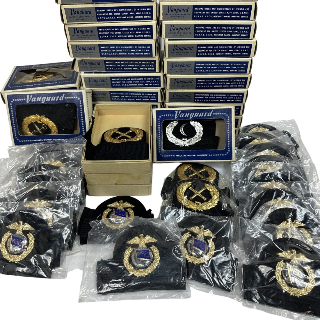 53 Vintage US Navy Cap Device Insignia w/ Band Lot MSC MSTS: Lot of 53 vintage US Navy cap device insignia with bands. Styles vary including MSC and MSTS. Some boxed and some just in plastic. All believed to be Vanguard brand.