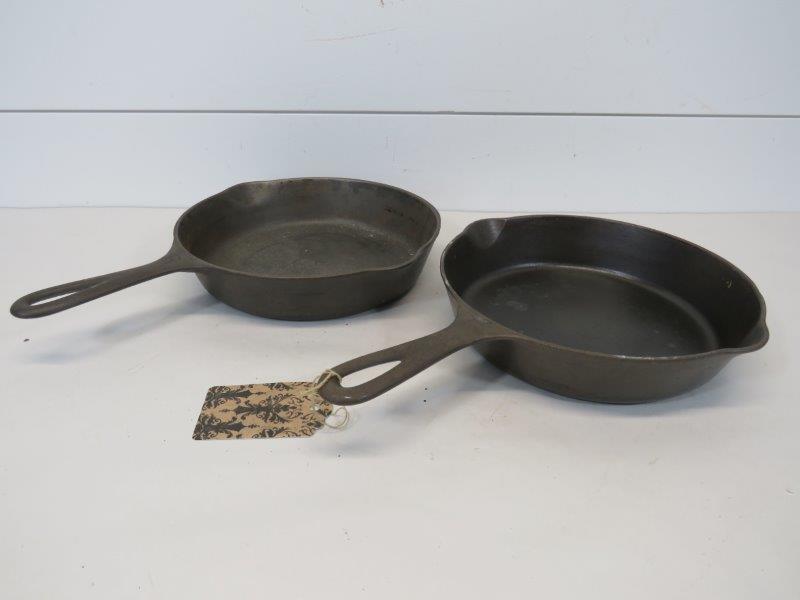 Griswold Large & Small Logo Cast Iron Skillets No. 6: Large Logo No. 6 marked: Erie PA, U.S.A. 699. Shows some wear and does wobble some, but very little pitting. Small Logo No. 6 marked: Erie PA 699J. Sits flat, but shows very mild pitting.&