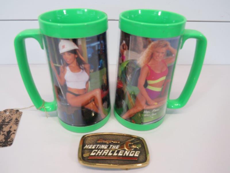 Vintage Snap-On Solid Brass Buckle & Pin-Up Mugs: This lot includes a solid brass belt buckle with some wear, as shown in photos, and a pair of pin-pin up girl Snap-On drinking mugs. The mugs are dated 1991 and have no chips, cracks or damage. B