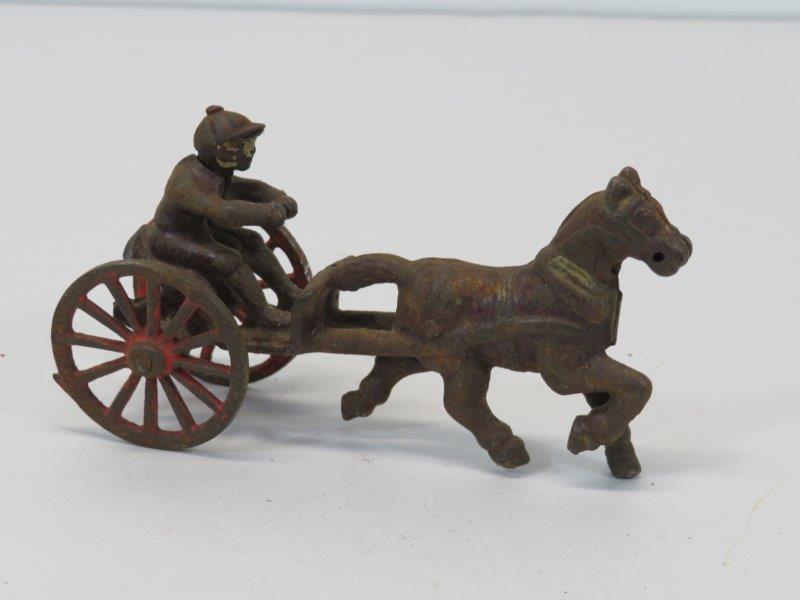 Antique Horse Drawn Sulky and Driver Cast Iron Toy: With some original paint remaining to the driver and wheels, with patina and rust consistent with age and wear, as noted in photos. 5" L 