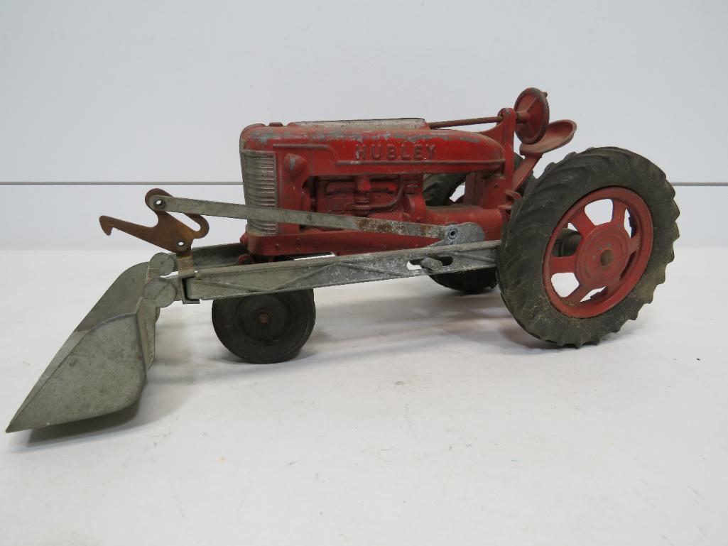 Hubley Cast Aluminum Tractor with Bucket Shovel: This item is shippable. We offer combined shipping in-house. Dimensions: 12" long with shovel down. 5" H x 5 1/2" D Some corrosion on the parts. Needs cleaned up. Photos will serve to re
