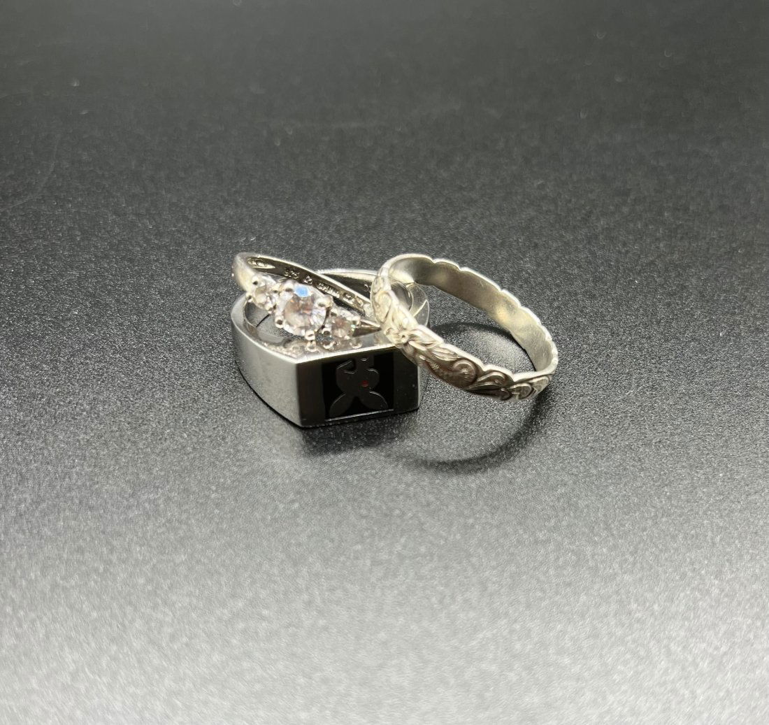 Diamond Silver Rings: (2) two Silver Ring and stamped 925. One of the two silver ring has synthetic Diamonds. The playboy ring has a stamp and we could not read the stamp. All the rings together weights: 9.2 grams . Silver