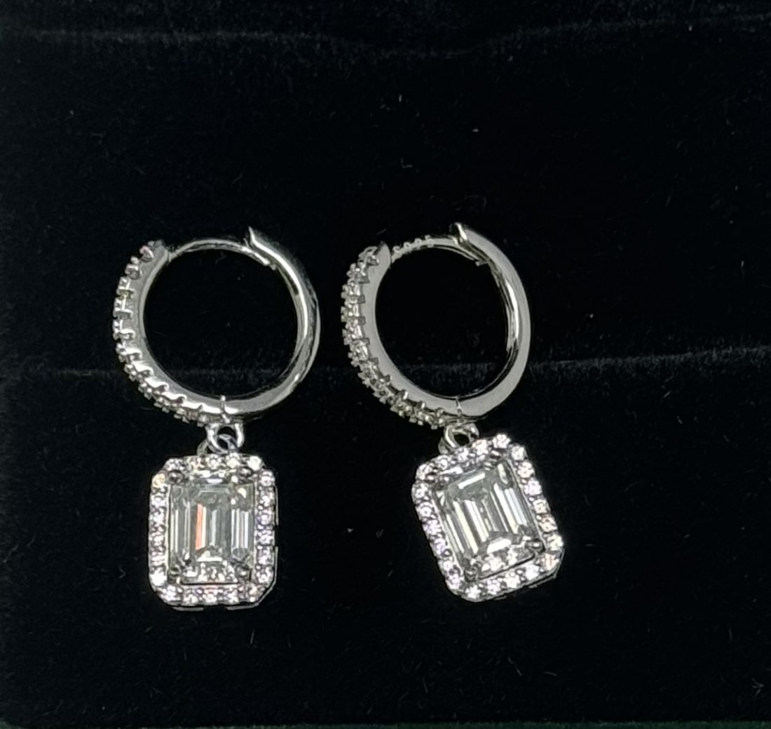 Emerald Cut Earrings: 18k White Gold plated on sterling silver Pair of Moissanite Emerald Cut VVS1 earrings , VVS1 Moissanite, Color Grade D , Weight: 1 carat each. It comes with GRA Certificate. stone passes for Diamond U