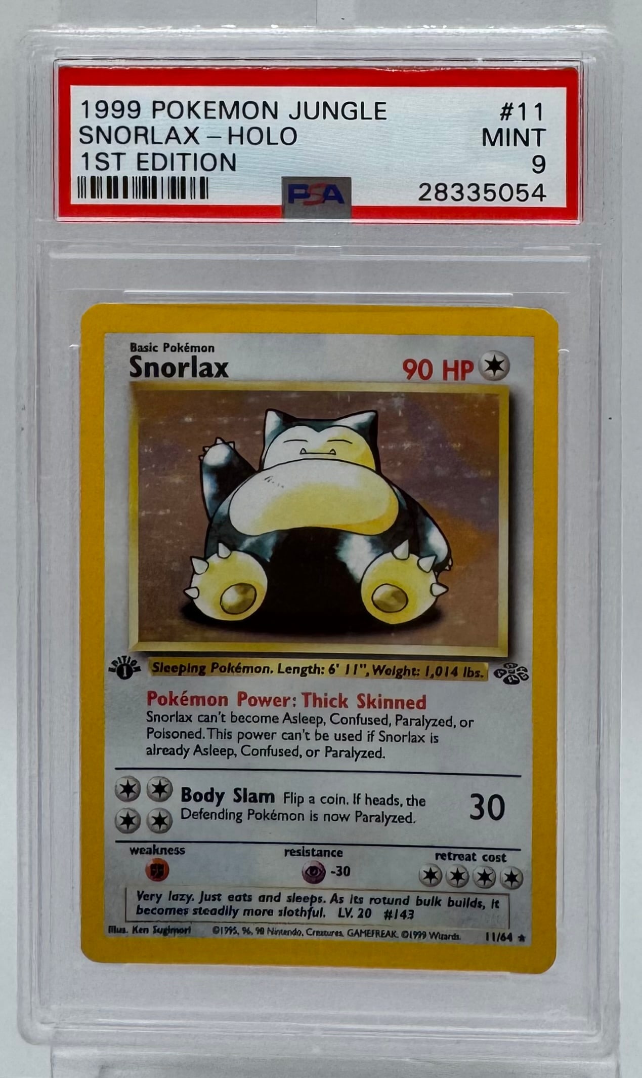 1999 Pokémon Jungle 1st Edition Snorlax Holo #11 PSA 9 MINT: A stunning 1st Edition Holo Snorlax from the Jungle set. Graded a PSA 9 Mint, this card is in exceptional condition. The 1st Edition stamp and the holographic finish make this a premium addition to