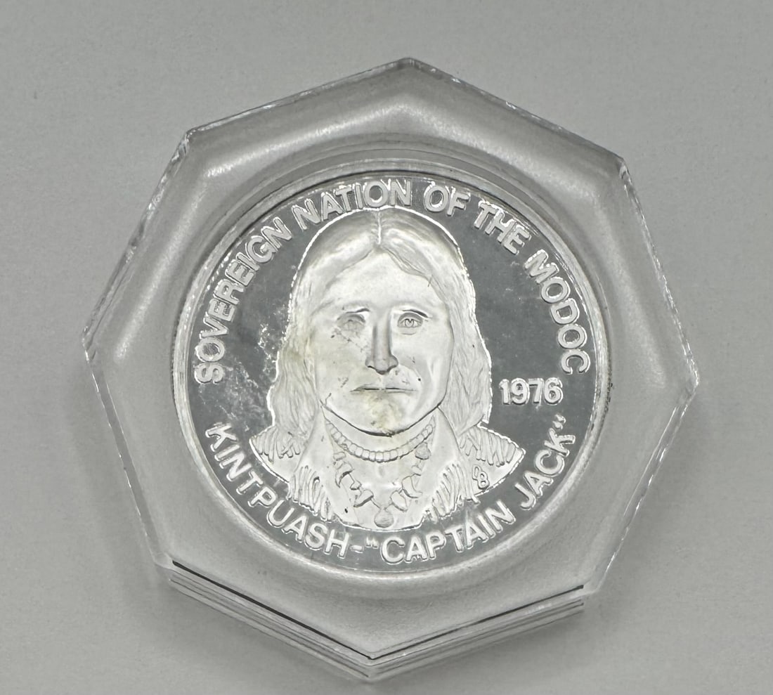 1976 .999 Silver Sovereign Nation of the Modoc Tribe Silver Round - "Captain Jack" - Proof-Like: This commemorative .999 fine silver round was struck in 1976 to honor the Sovereign Nation of the Modoc Tribe. The obverse features a detailed portrait of Kintpuash, famously known as "Captain Jack,"