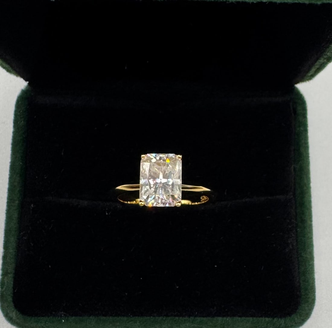 3.00 CT Radiant Cut Moissanite Solitaire - 18K Yellow Gold Plated: Stunning 3.00 Carat Radiant Cut Moissanite. • Metal: 18K Yellow Gold Plated over Solid .925 Sterling Silver. • Design: Elegant 4-prong solitaire setting on a slim, high-polish yellow gold