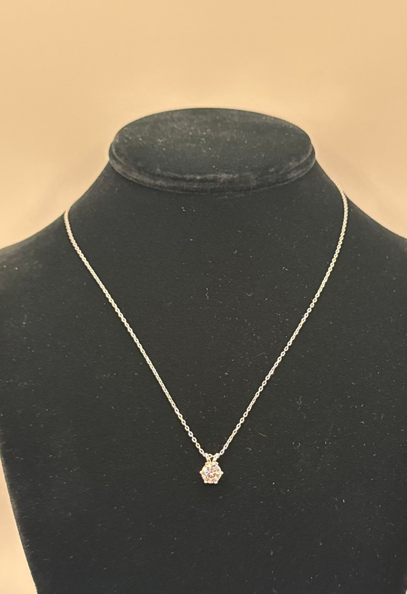 1.00 CT Round Brilliant Moissanite Solitaire Necklace - 18K White Gold Plated: Genuine 1.00 Carat Round Brilliant Cut Moissanite. • Metal: 18K White Gold Plated over Solid .925 Sterling Silver. • Design: Elegant 6-prong solitaire setting on a classic silver-tone