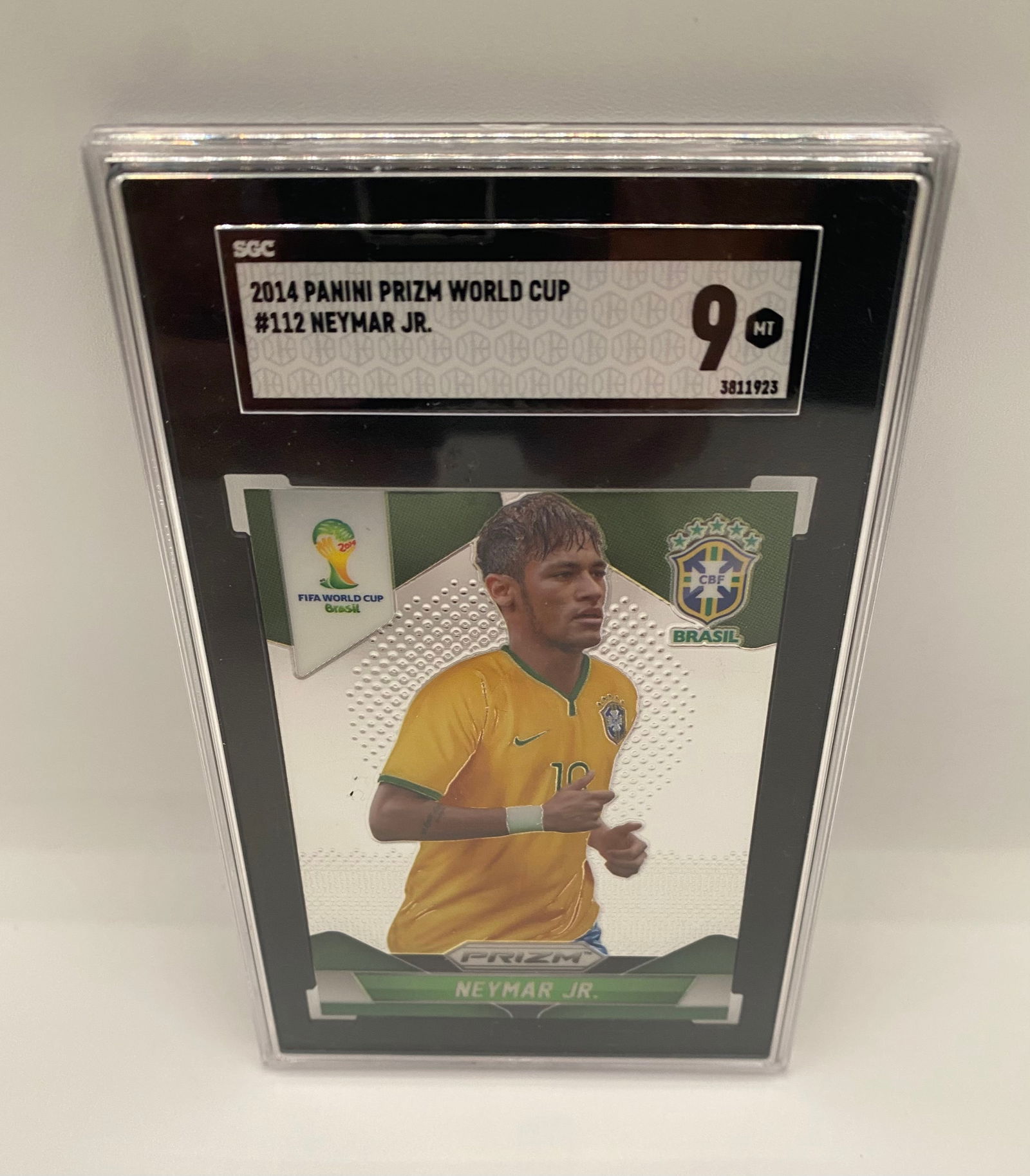 2014 Panini Prizm World Cup Neymar Jr. #112 SGC 9 MINT Brasil: A classic piece of modern soccer history. This 2014 Panini Prizm Neymar Jr. card celebrates his legendary tenure with Brasil during the 2014 World Cup. Graded a Mint 9 by SGC, it is housed in the