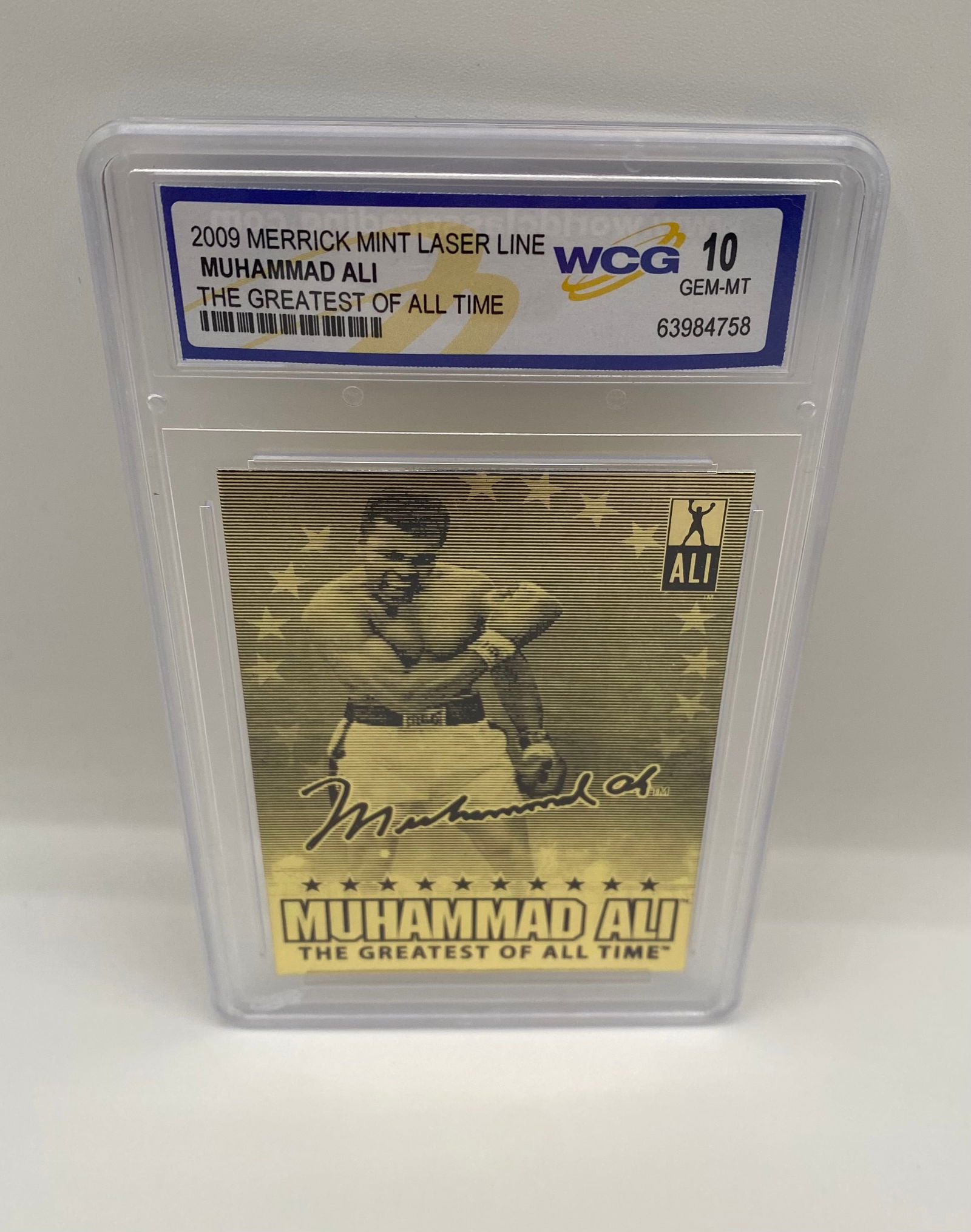2009 Merrick Mint Laser Line Muhammad Ali The Greatest of All Time WCG 10 GEM-MT: A spectacular tribute to "The Greatest." This 2009 Merrick Mint Laser Line card features a gold-etched aesthetic and a facsimile signature. Graded GEM MINT 10 by WCG.