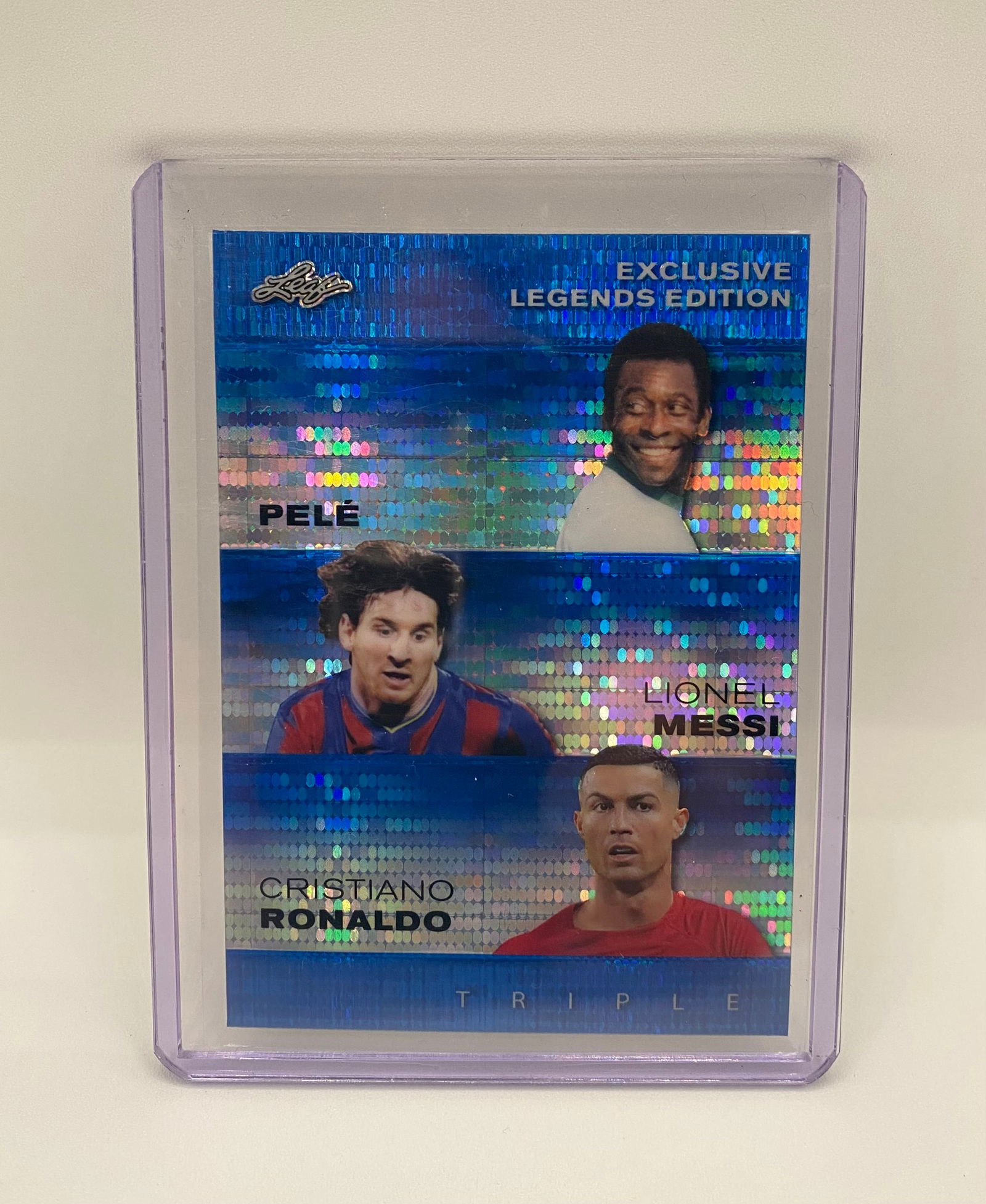 2024 Leaf Exclusive Legends Edition Triple Messi/Ronaldo/Pelé Blue Sparkle /20: A stunning Blue Sparkle/Refractor variation of the Leaf Exclusive Legends Triple card. It showcases Pelé, Lionel Messi, and Cristiano Ronaldo in a vibrant, multi-color mosaic finish. This card