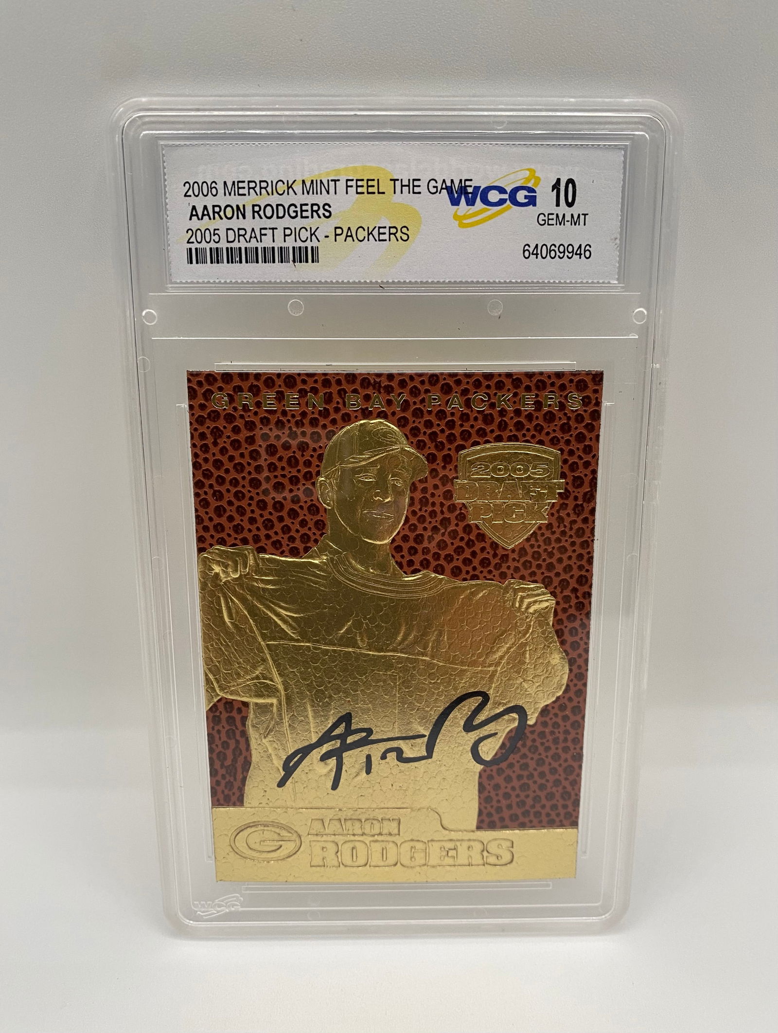 2006 Merrick Mint "Feel The Game" Aaron Rodgers 2005 Draft Pick - WCG 10 GEM-MT: A unique gold-on-football texture card commemorating Aaron Rodgers as a 2005 first-round draft pick. Graded GEM-MT 10 by WCG. Features a facsimile signature and Feel The Game textured background. 
