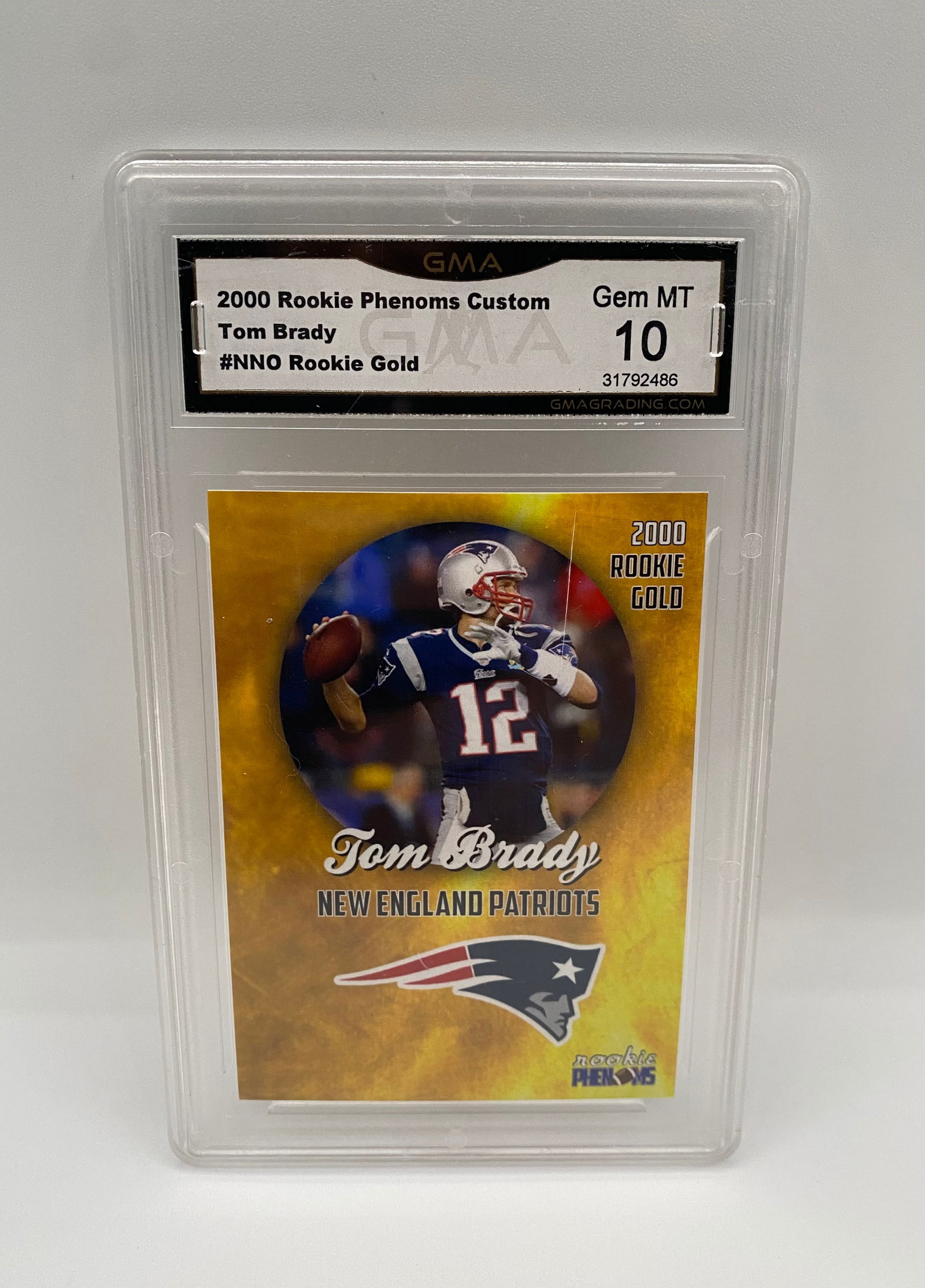 2000 Rookie Phenoms Custom Tom Brady #NNO Rookie Gold - GMA 10 GEM MT: A "Rookie Phenoms Custom" 2000 Tom Brady card featuring the New England Patriots logo and a gold-themed background. Graded GEM MT 10 by GMA. A high-appeal item for Brady completionists. 