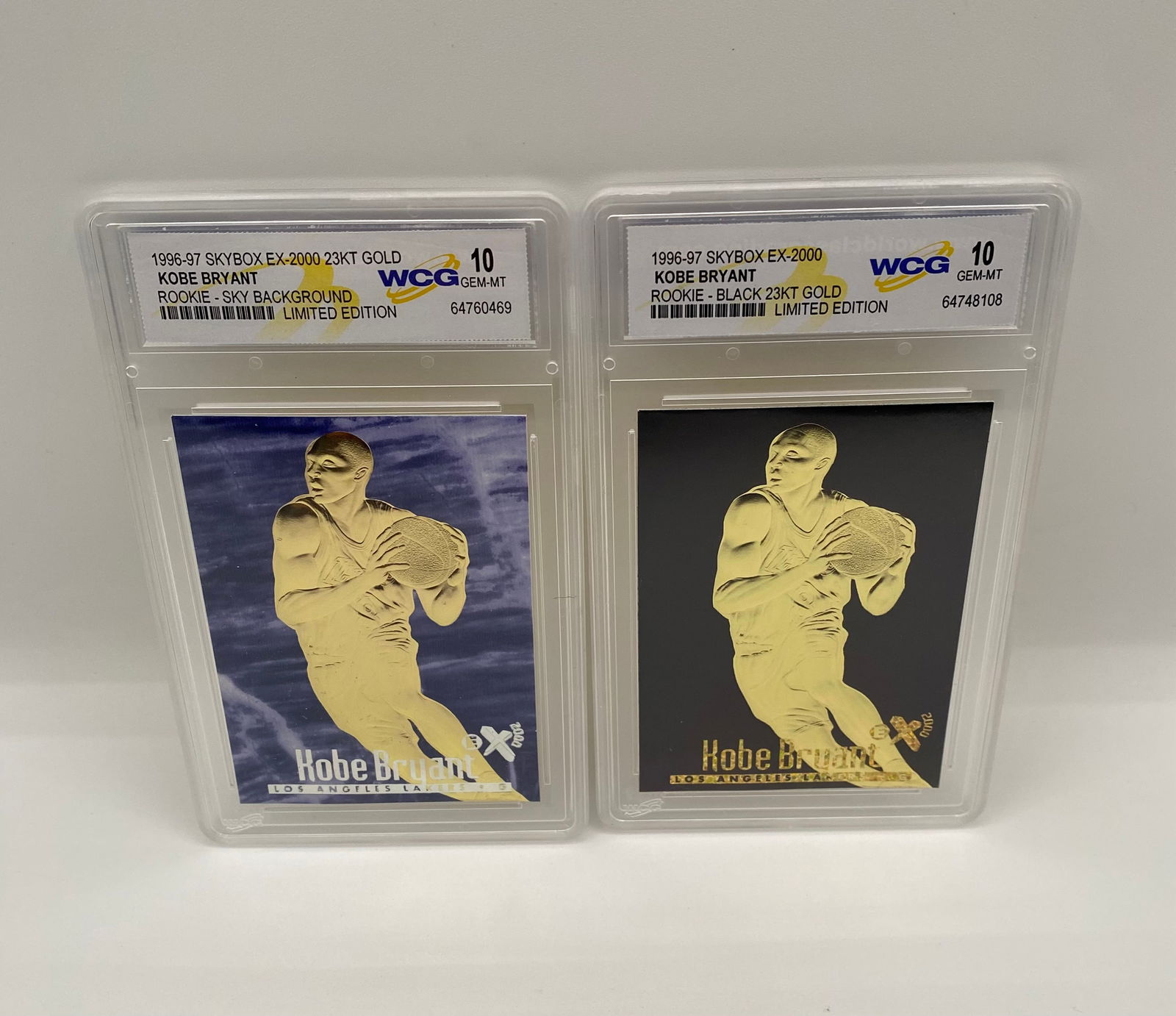 (2) Kobe Bryant 1996-97 SkyBox EX-2000 23KT Gold Rookie Tributes - WCG 10: Card 1: 1996-97 SkyBox EX-2000 23KT Gold "Sky Background" Limited Edition. • Card 2: 1996-97 SkyBox EX-2000 23KT Gold "Black Background" Limited Edition. • Details: High-grade 23-karat