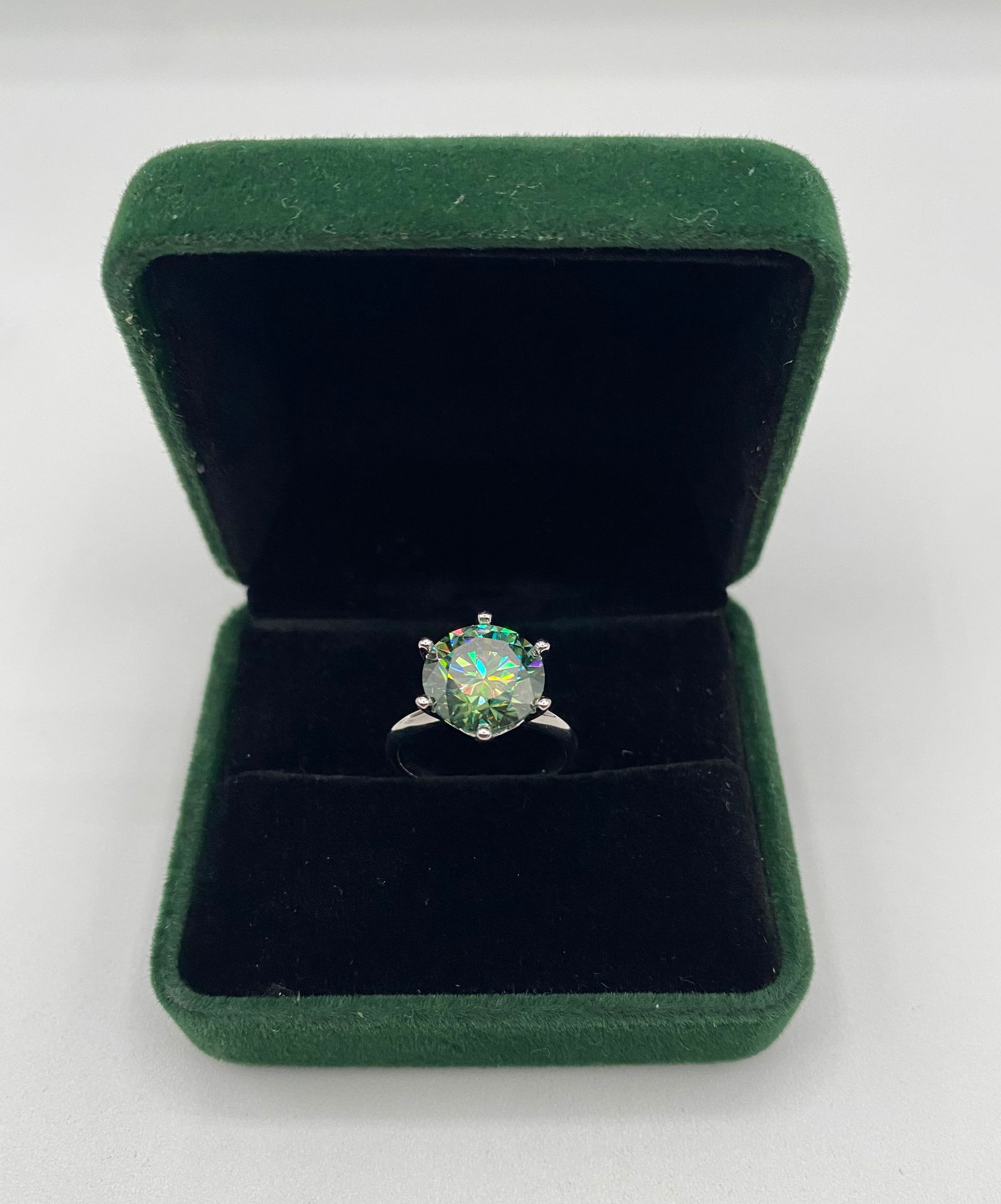 5.00 CT Blue-Green Moissanite Solitaire Ring - GRA Certified - White Gold Finish: Center Stone: 5.00 Carat Round Cut Moissanite with a unique Blue-Green/Teal fire. • Metal: 18K White Gold/Rhodium plated over .925 Sterling Silver. • Design: Minimalist 6-prong