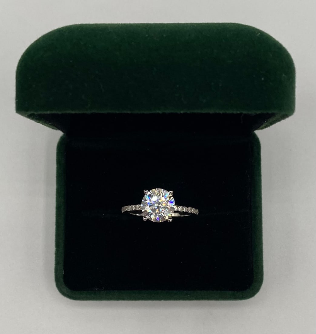 3.00 CTW Round Brilliant Cut Moissanite Solitaire Ring - GRA Certified - 18K White Gold Over Silver: Up for auction is a stunning 3.0 carat round brilliant cut moissanite engagement-style ring. This high-quality stone possesses exceptional fire and brilliance, professionally tested to pass as a