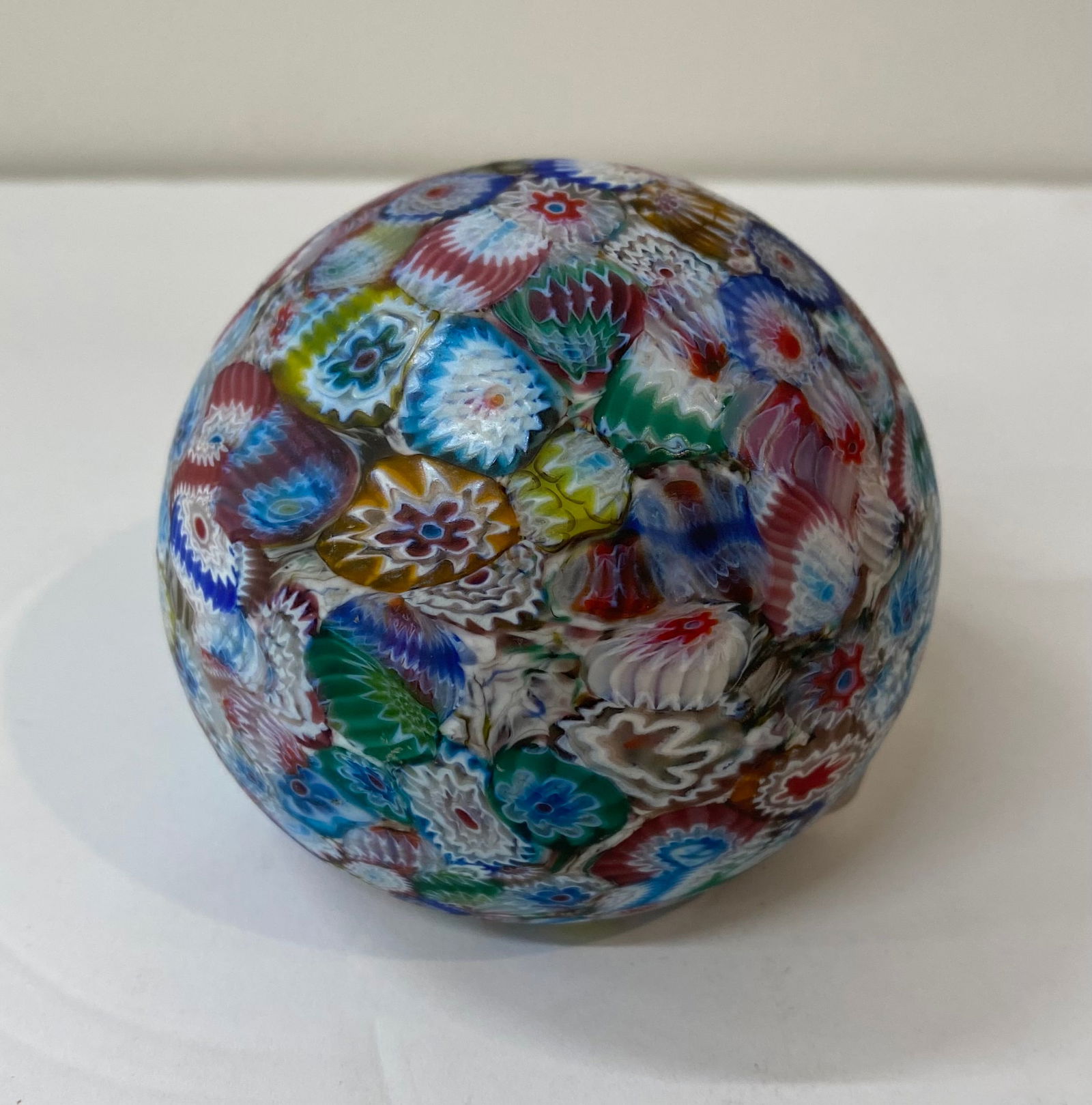 Vintage Millefiori Multi-Color Art Glass Sphere Paperweight: A vibrant art glass paperweight featuring a dense, all-over Millefiori (thousand flowers) design. This piece showcases a variety of intricate cane patterns in brilliant blues, reds, greens, and