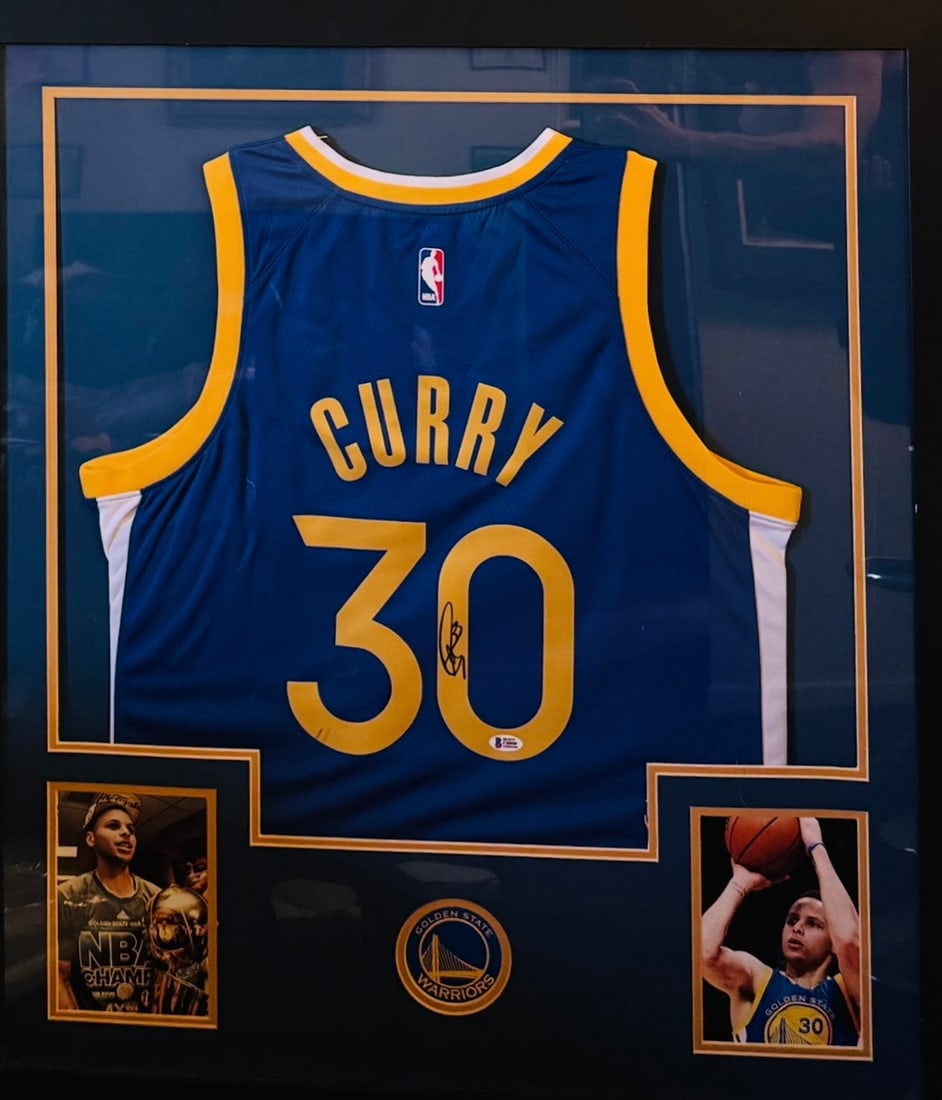 Stephen Curry Signed & Framed Golden State Warriors Jersey - Beckett COA: Up for auction is a premium, custom-framed display featuring an autographed jersey from 4x NBA Champion and 2x MVP, Stephen Curry. This collector’s piece showcases the iconic Golden State