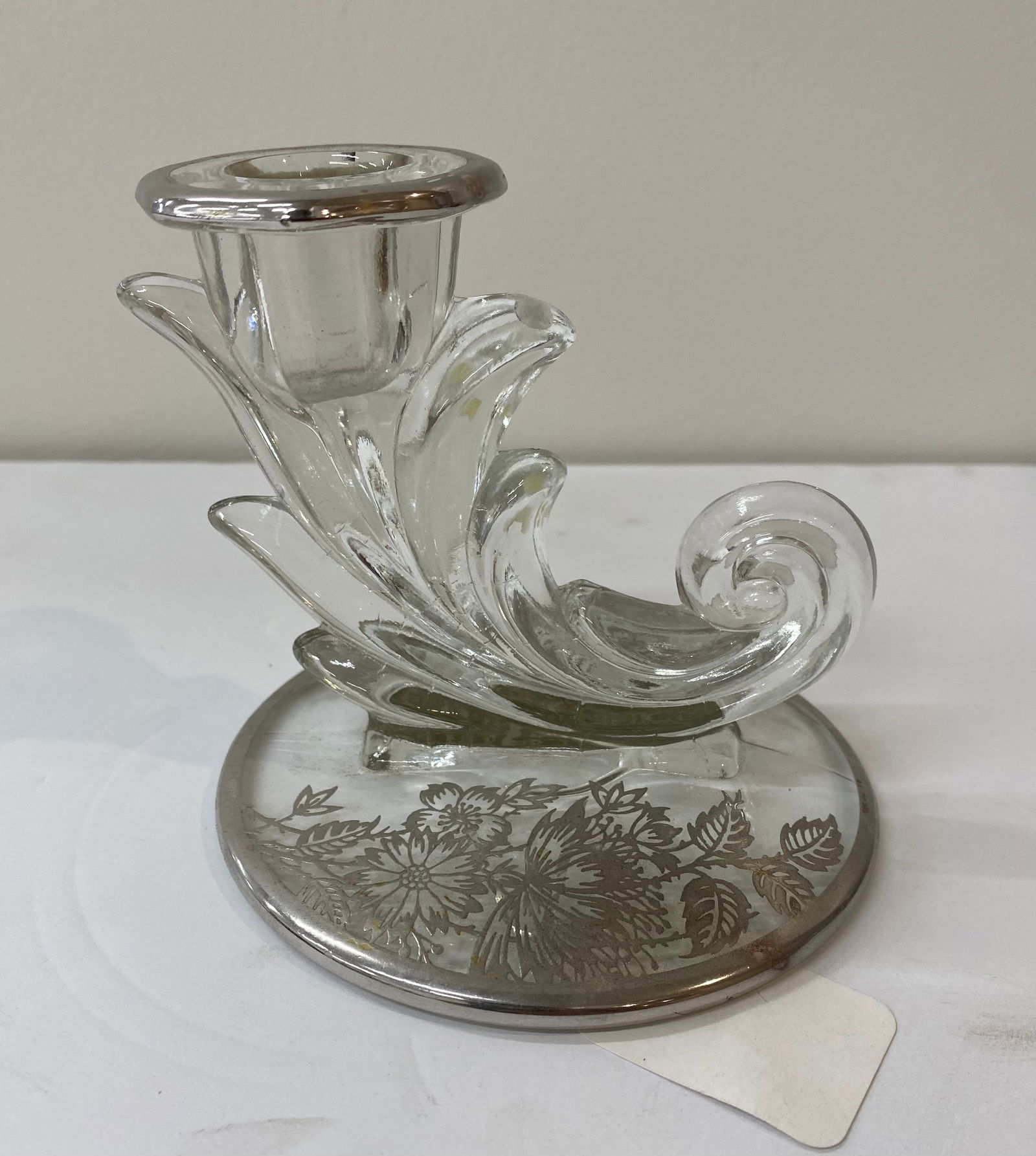 Mid-Century Modern Silver Overlay Crystal Cornucopia Candlestick: A graceful crystal candlestick holder in a scrolled cornucopia or "swan" shape. The wide circular base features a delicate sterling silver overlay floral pattern. The rim of the candle cup is also