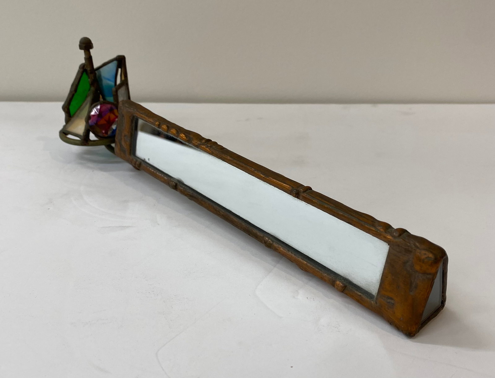 Vintage Handcrafted Stained Glass & Brass Kaleidoscope: A beautiful artisan-made kaleidoscope featuring a brass-tone metal frame with a stained glass exterior housing. The end chamber contains tumbled glass and jewels that create vibrant geometric patterns
