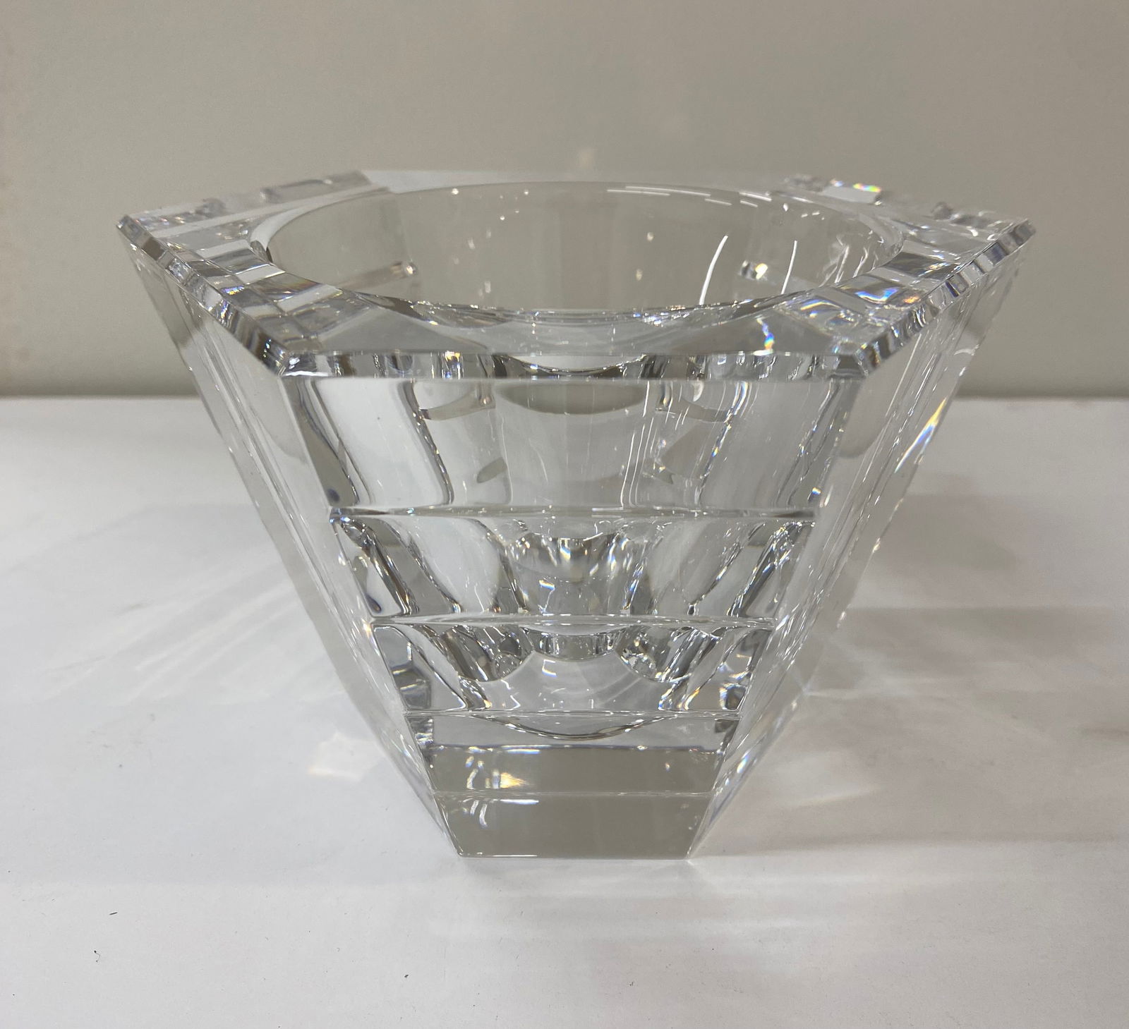 Contemporary Geometric Faceted Clear Lead Crystal Votive or Tealight Holder: A sophisticated and heavy-weighted candle holder crafted from high-quality clear lead crystal. The piece features a bold, geometric architectural design with deep horizontal facets and a tapered
