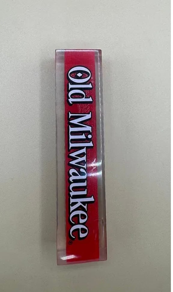 Vintage Old Milwaukee Beer Tap Handle - Red Lucite/Acrylic: A classic "lucite" style rectangular tap handle for Old Milwaukee. Features the traditional brand logo in white with black outlining set against a bright red internal background. Simple, durable, and