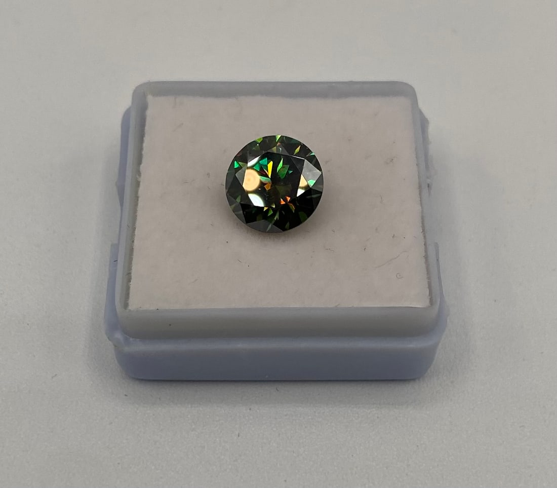 3.00ct Deep Green Moissanite Round Brilliant Cut - GRA Certified: Offered is a stunning 3.00 carat round brilliant cut Moissanite featuring a rare and captivating Deep Green hue. This laboratory-grown gemstone displays exceptional fire and scintillation,