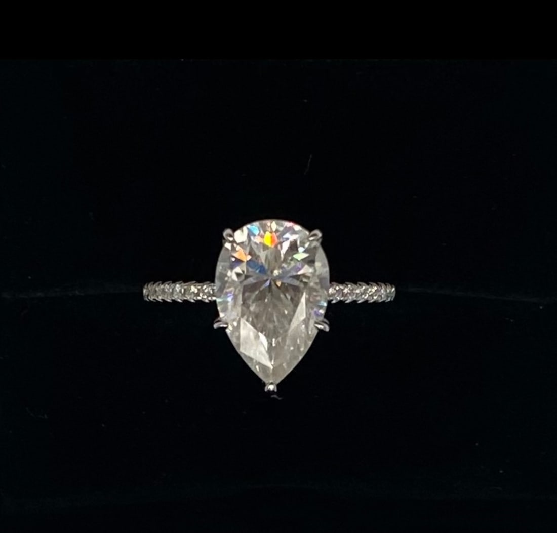 NEW 5 Carat Pear Moissanite Ring, GRA Certified, Size 8: This exquisite, brand-new ring features a brilliant 5-carat pear-cut moissanite stone that offers exceptional fire and brilliance. Professionally crafted for the collector or jewelry