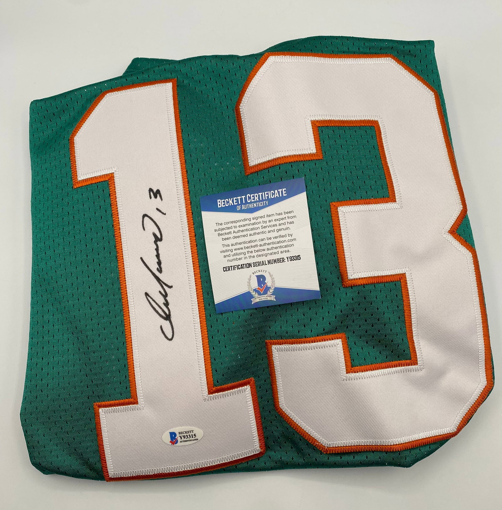 Dan Marino Autographed Jersey Beckett COA: An absolute must-have for football purists, this classic mesh-style custom jersey is signed by legendary Hall of Fame quarterback Dan Marino. The bold signature is executed in black marker on the