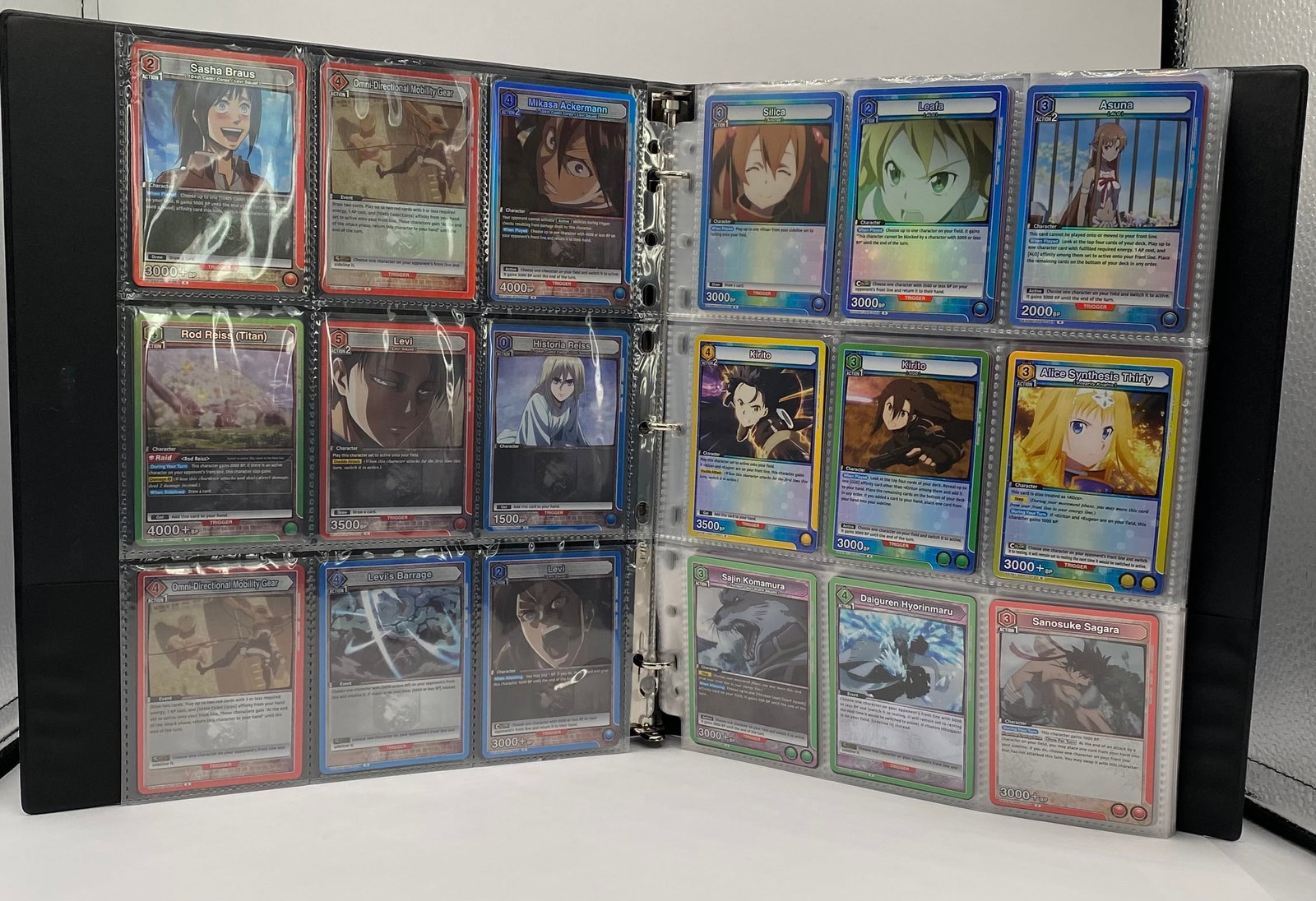 Union Arena Binder Collection Bleach, Attack on Titan, Sword Art Online, Demon Slayer & More: Up for auction is a premium multi-page binder collection of the hit anime crossover trading card game, Union Arena TCG. Perfect for collectors and competitive players alike, this lot features a divers