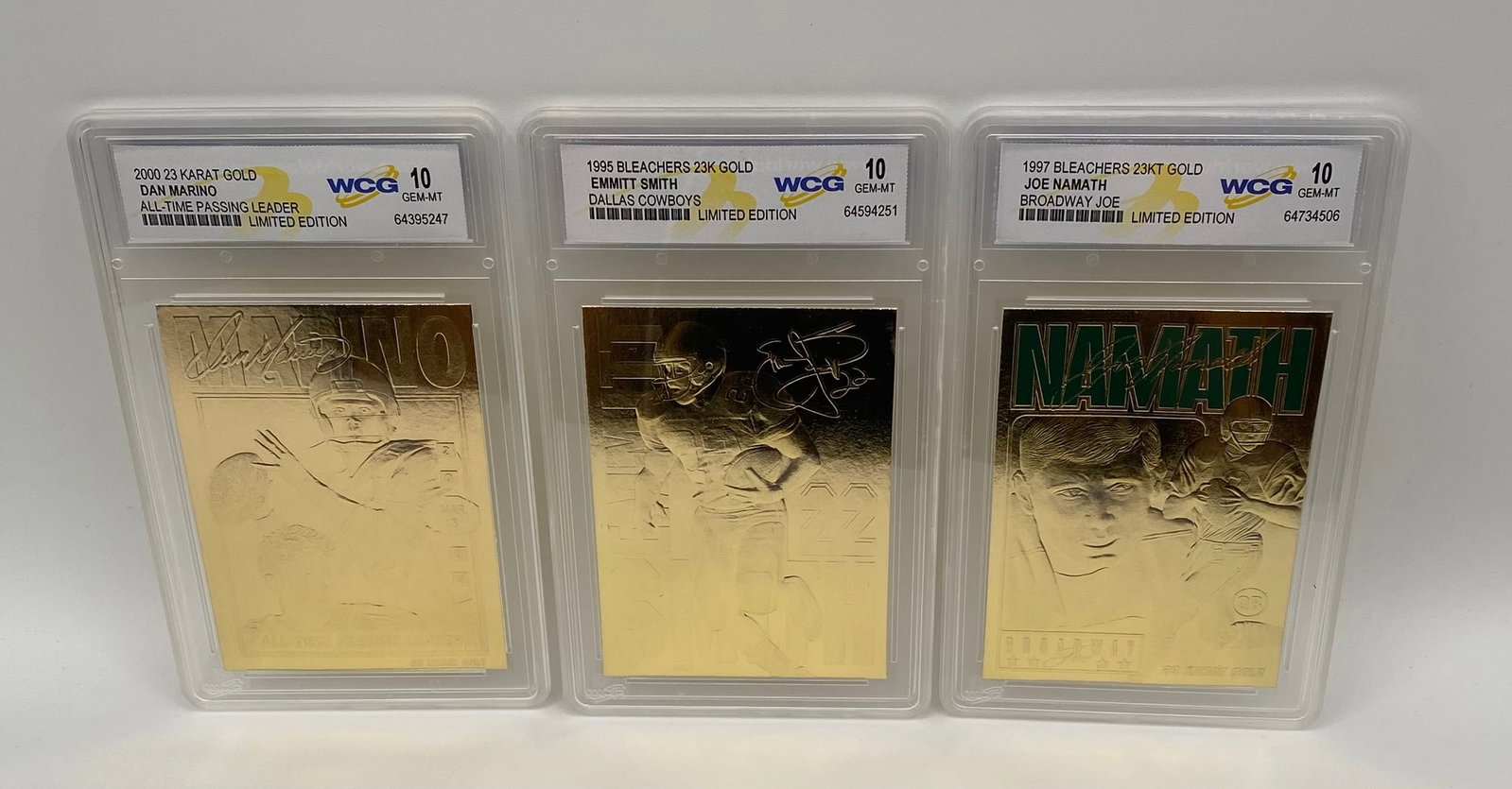 Dan Marino , Emmitt Smith & Joe Namath Cards: A stellar three-card lot of NFL gridiron royalty, struck in gleaming 23 Karat Gold. Each card is beautifully preserved and graded Gem-MT 10 by WCG. All are designated Limited Editions. Dan Marino: 200