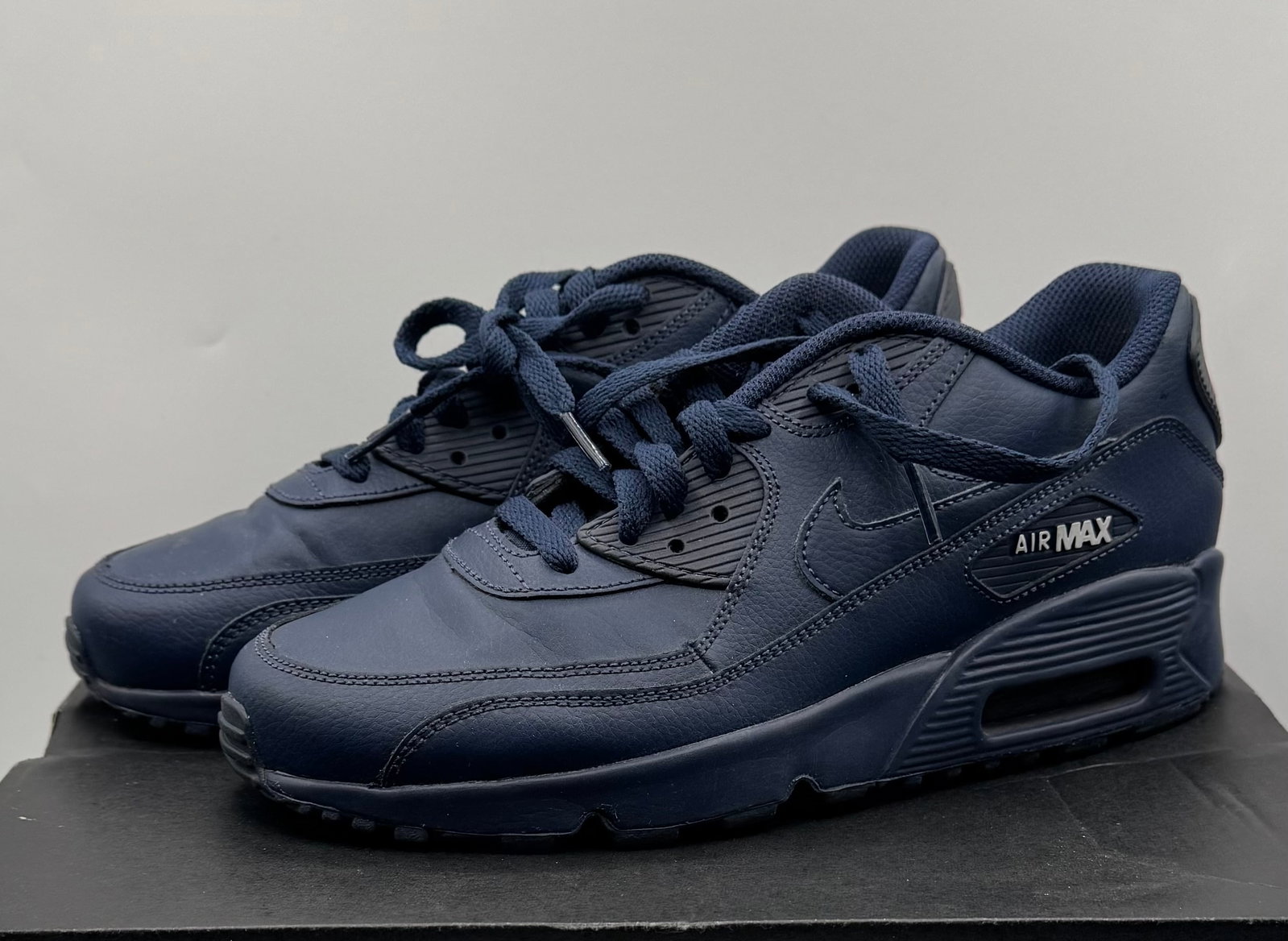 Nike Air Max 90 Leather Sneakers Triple Navy Blue: A clean pair of Nike Air Max 90 Leather sneakers presented in a sharp, monochromatic Triple Navy Blue colorway. This timeless silhouette features an all-leather upper, classic ribbed plastic accents,