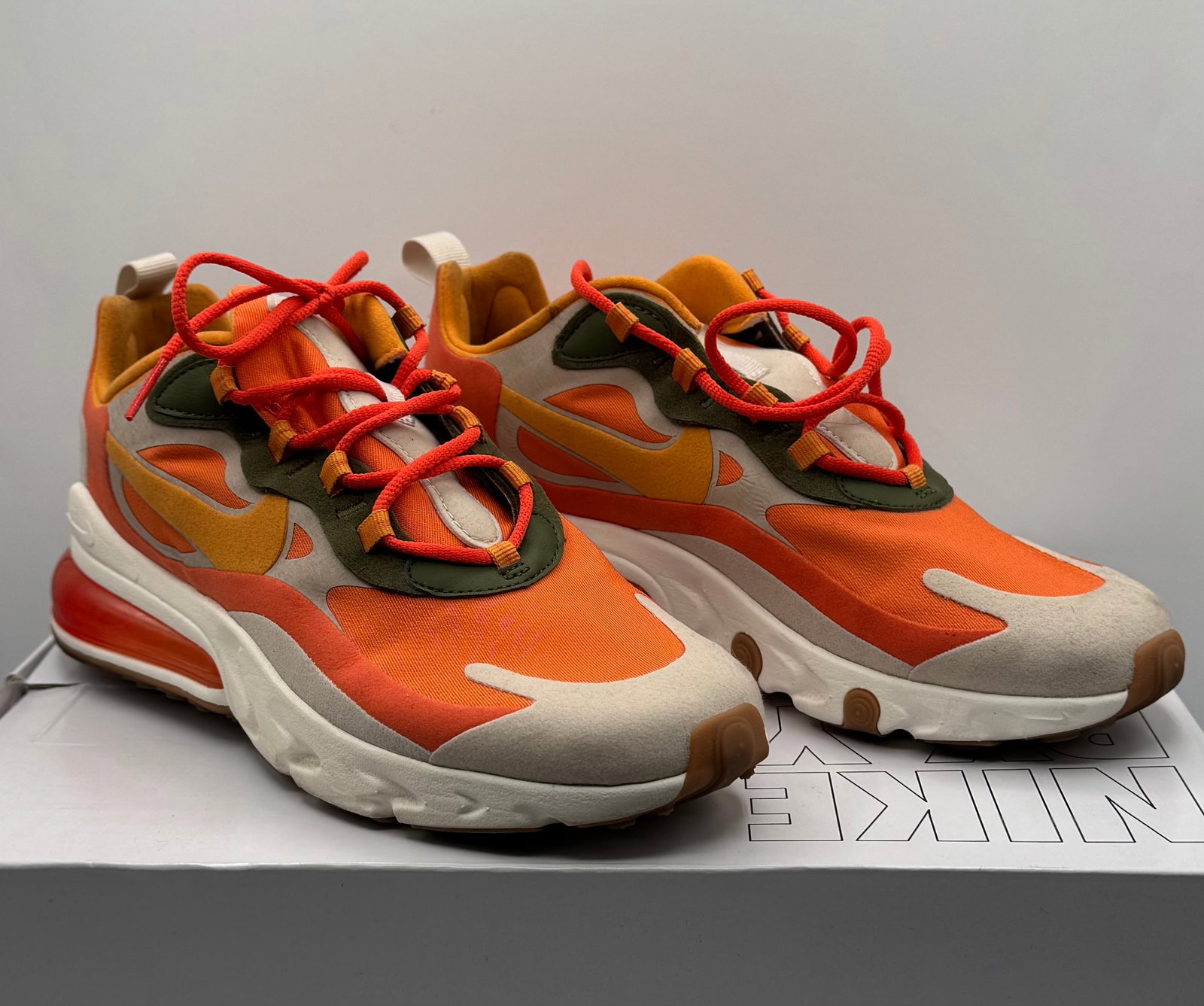 Nike Air Max 270 React Nike By YouSneakers: A striking pair of Nike Air Max 270 React lifestyle sneakers, customized via the exclusive "Nike By You" (formerly NIKEiD) platform. This unique colorway features a vibrant, autumn-inspired palette