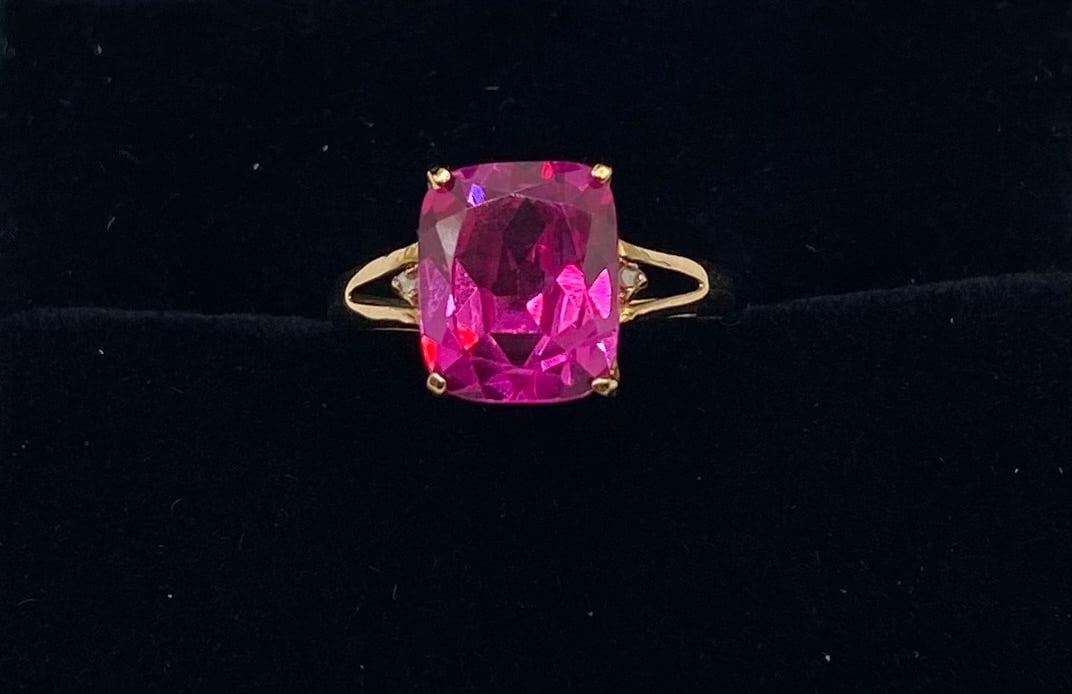 Vintage 10K Gold Ruby Ring: Up for auction is a striking vintage statement cocktail ring crafted in 10K yellow gold, featuring a vibrant, cushion-cut synthetic ruby. The center stone exhibits a brilliant, intense pinkish-red