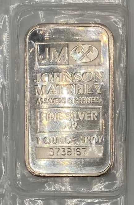 Johnson Matthey (JM) 1 Troy Ounce .999 Fine Silver Bar: A classic, highly collectible 1 Troy Ounce silver bullion bar minted by the world-renowned assayers and refiners, Johnson Matthey. Design: Features the iconic JM logo with crossed hammers, stamped "JO