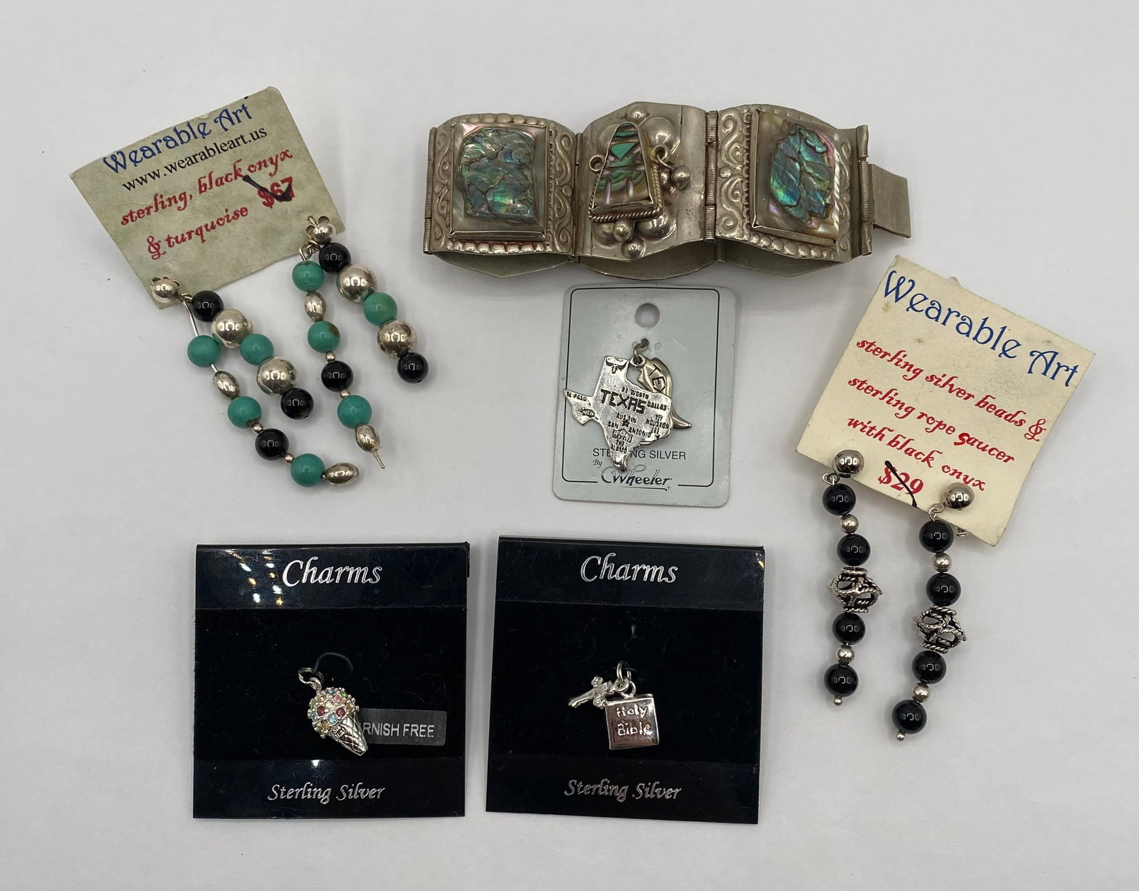 Vintage Sterling Silver Jewelry & Charms - 83g Total Weight, Abalone, Onyx, Turquoise: An excellent estate lot featuring a diverse collection of vintage sterling silver jewelry, including a bold statement bracelet, two pairs of artisan-crafted earrings, and three sterling charms. The