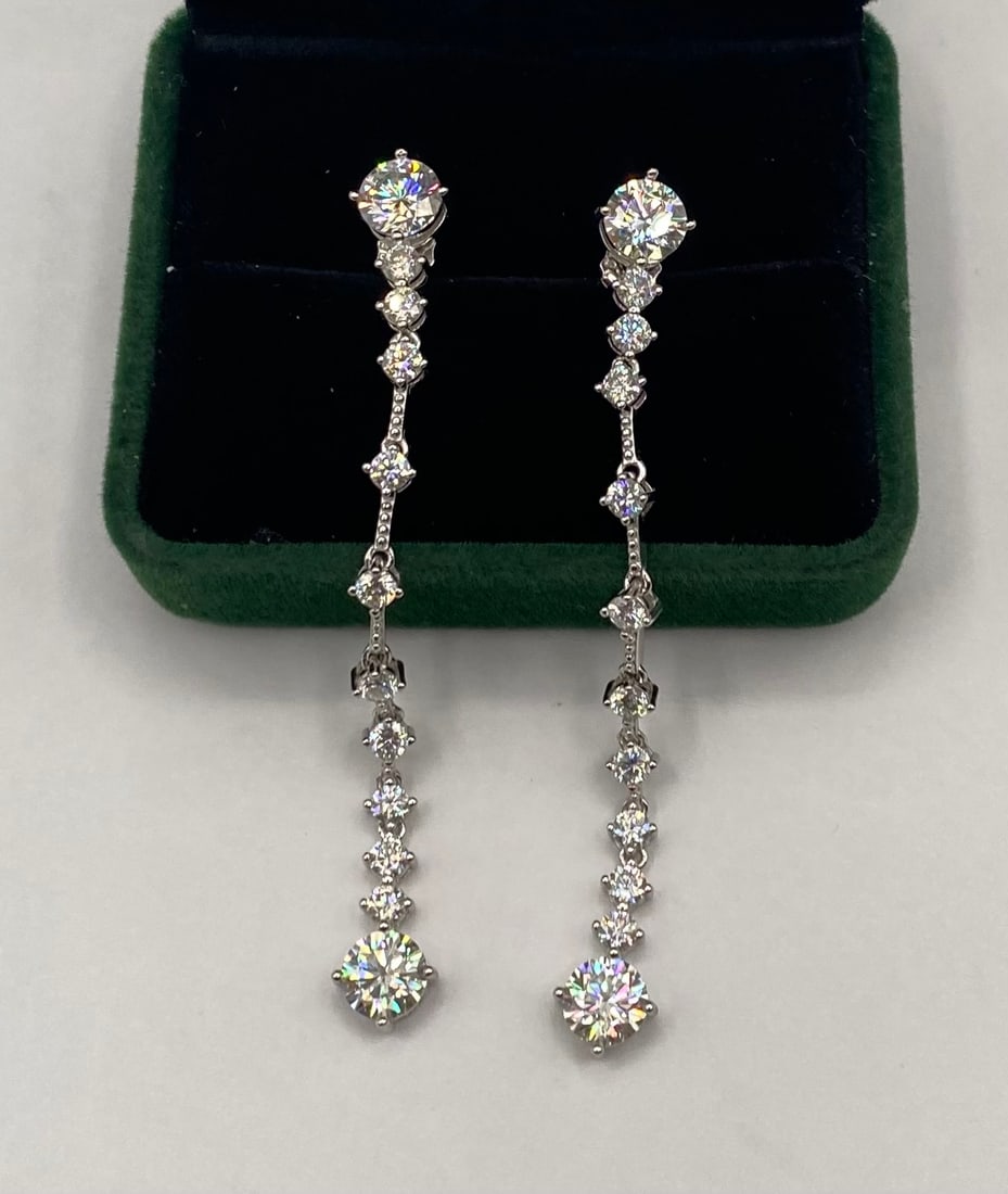 Magnificent 6.00 CTW Round Brilliant Moissanite Drop Earrings: Make a brilliant statement with this spectacular pair of articulated linear drop earrings. Featuring an impressive total weight of approximately 6.00 carats (approx. 3.00 carats per side), these