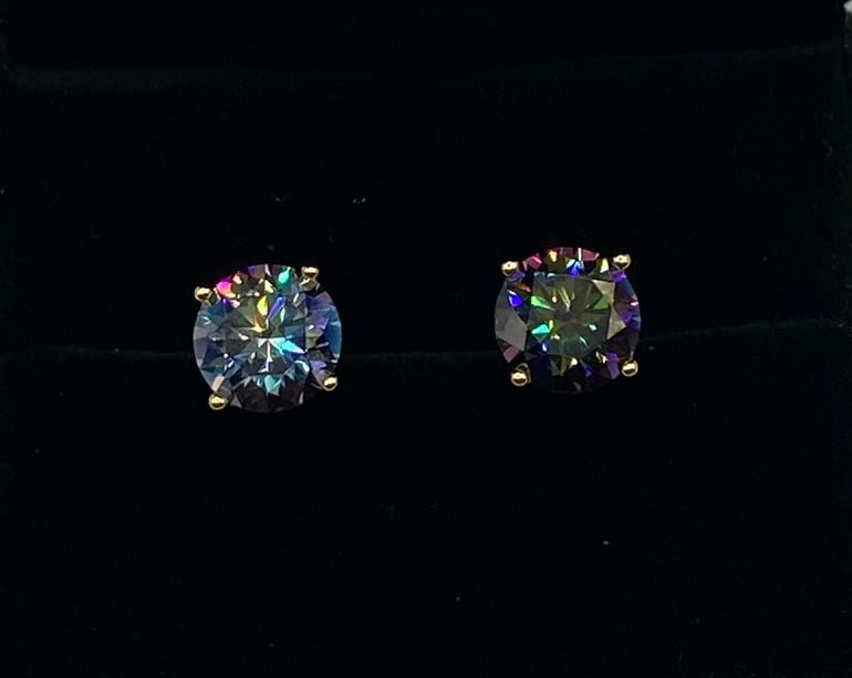 6 CTW Rainbow Moissanite Stud Earrings: Up for auction is a magnificent pair of round-cut Moissanite stud earrings, boasting a total weight of 6.00 carats (3.00 carats per earring). These stones display an incredible, vibrant rainbow fire a