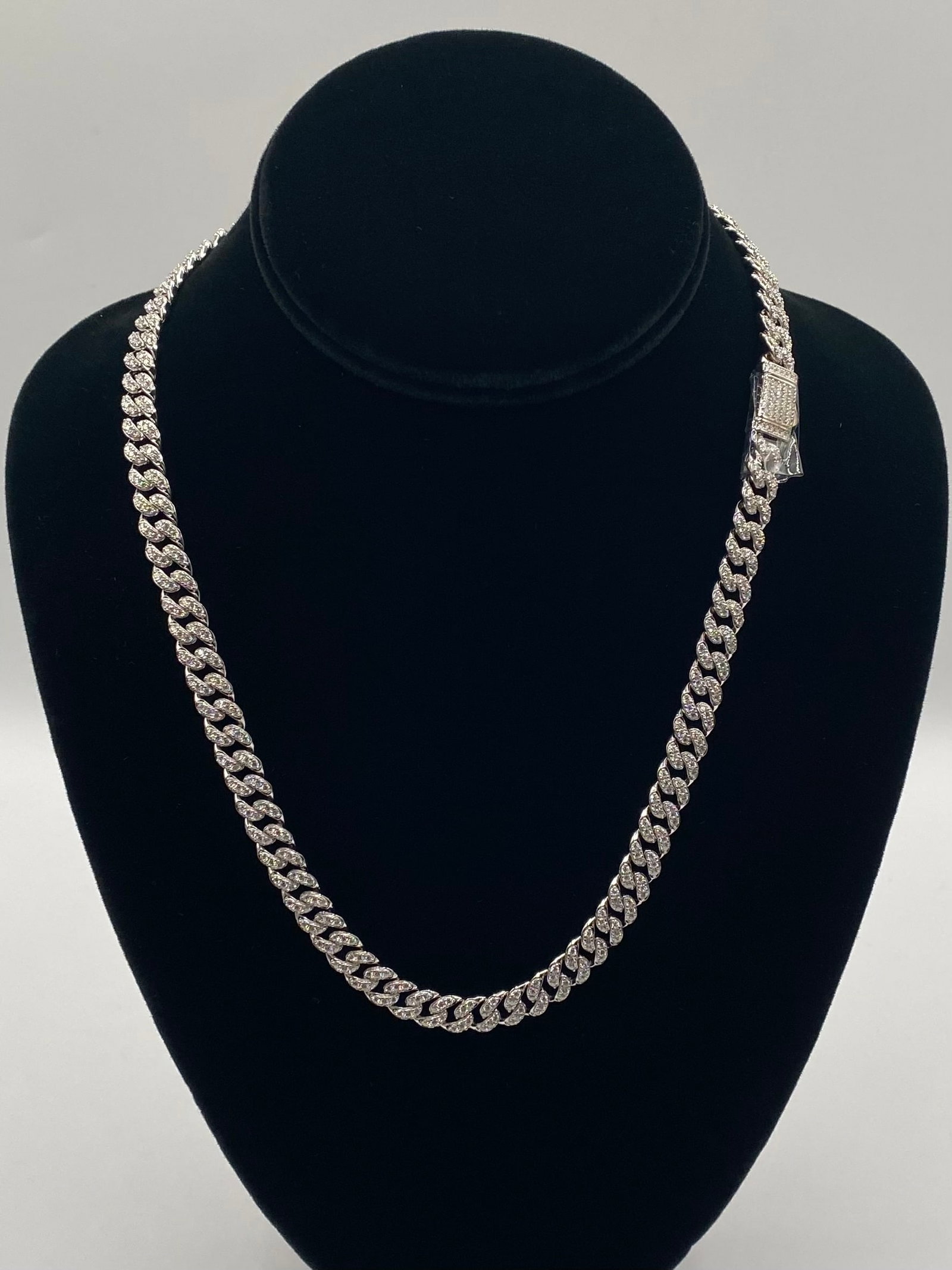 20" Moissanite Iced-Out Cuban Link Chain Necklace - 18K White Gold Vermeil: Style: Classic Cuban Link / Miami Cuban Chain Length: 20 Inches Gemstones: Premium Round Brilliant Cut Moissanite Stones (Fully iced-out across the links and the sleek security clasp) Metal Compositio